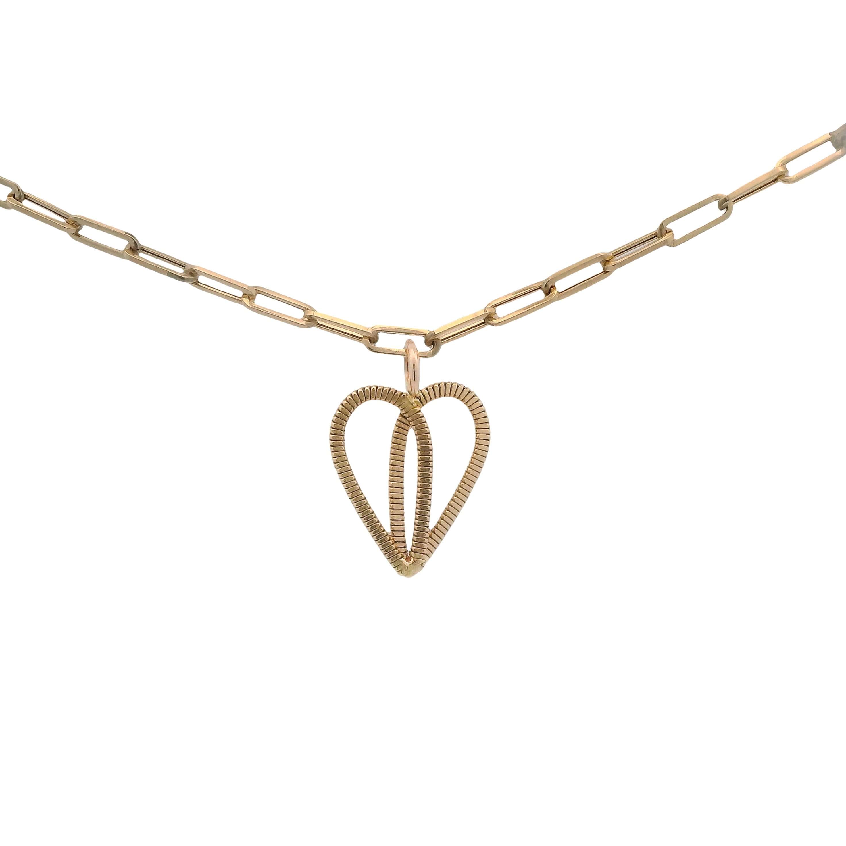 Gold guitar string heart on gold paperclip chain with white background.