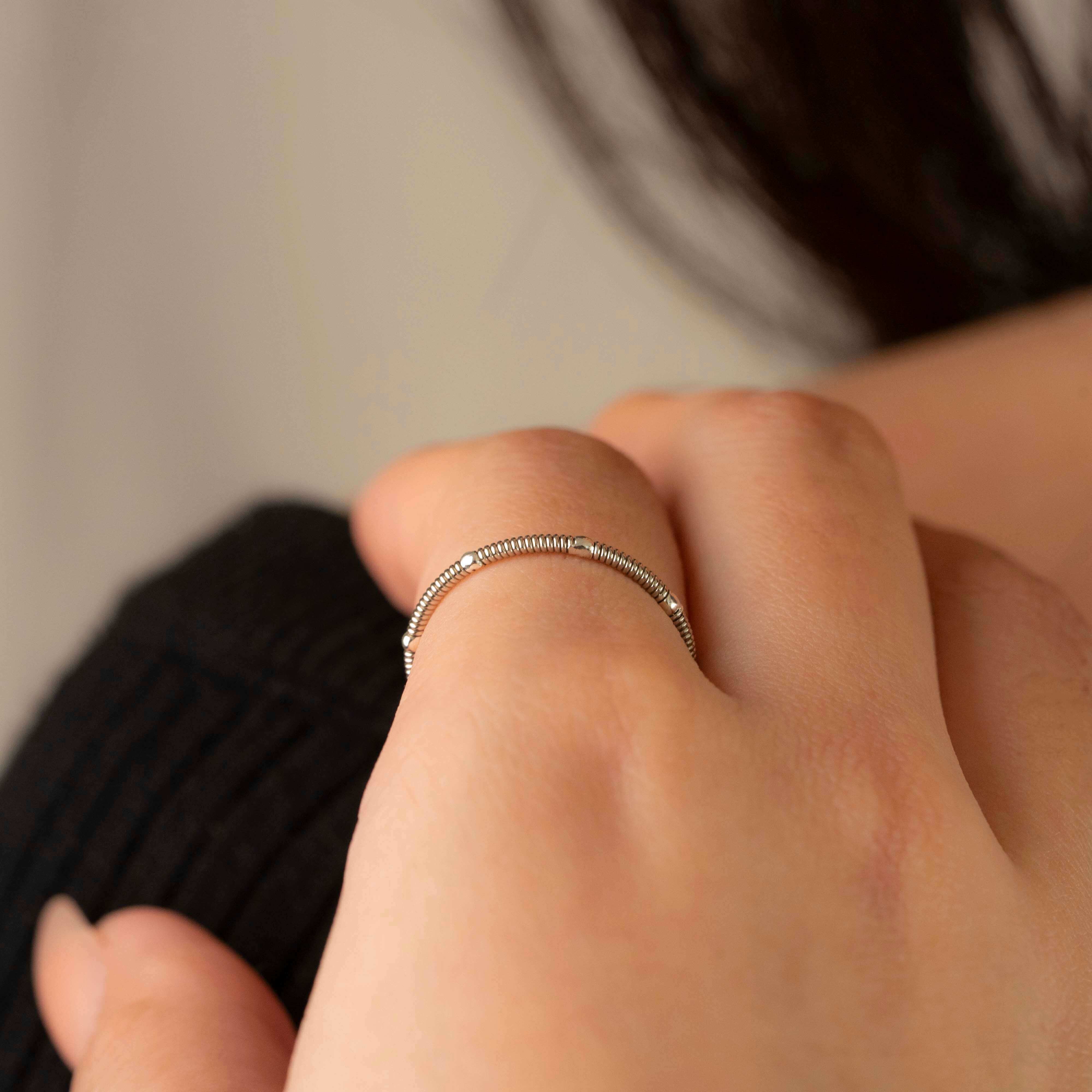 Guitar string stacking ring with silver drops on model close-up