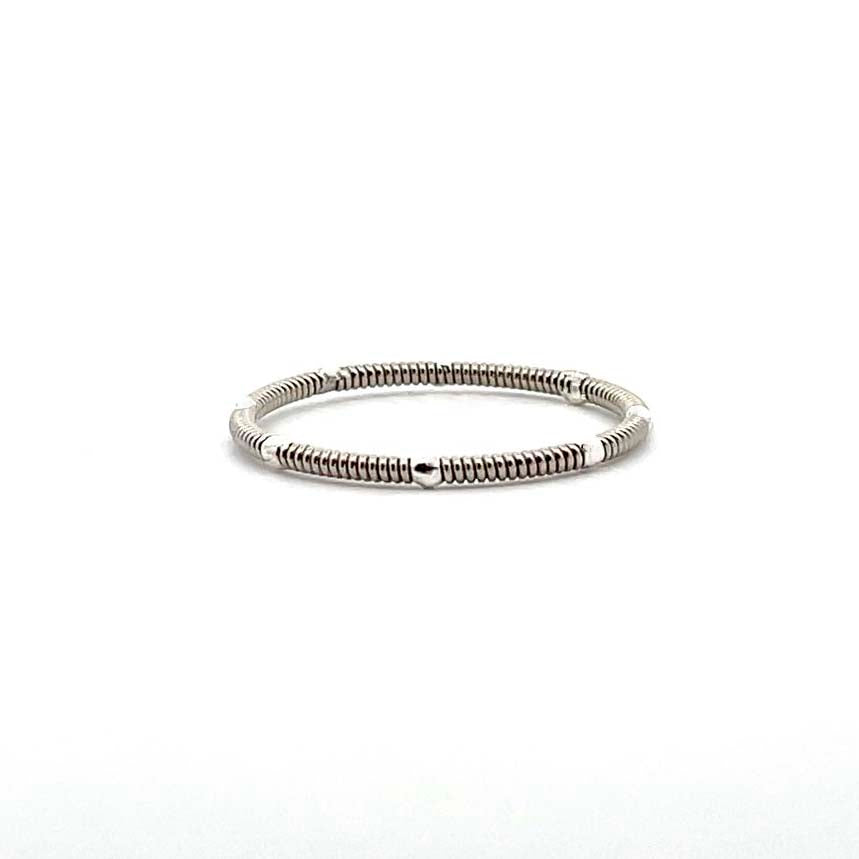 Guitar string and silver stacking ring on white background