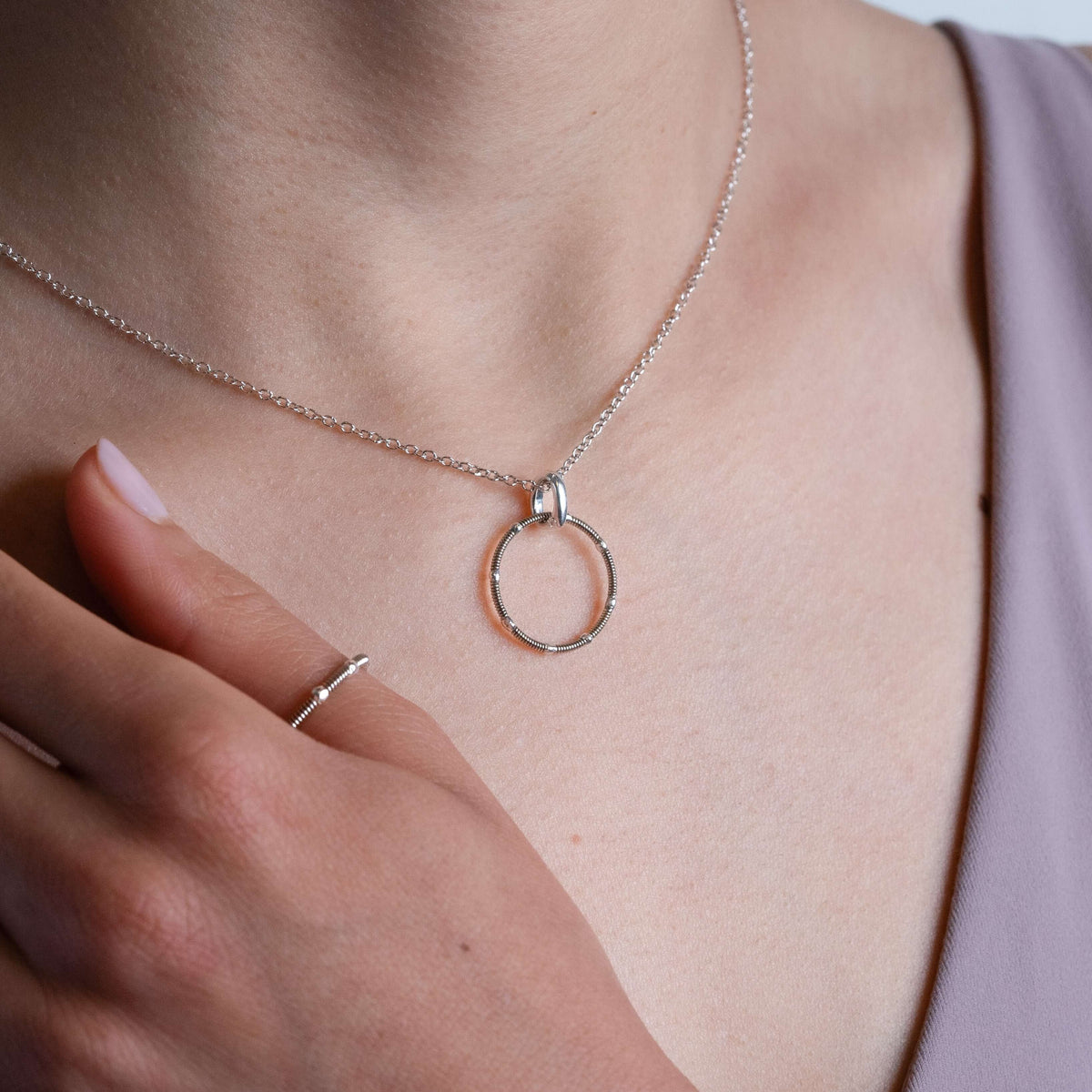 Silver guitar string ring and necklace on model