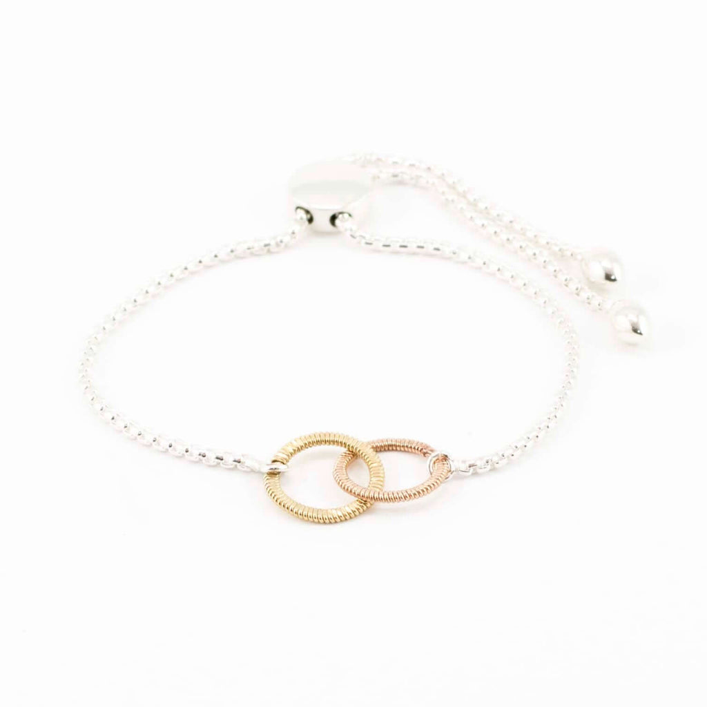 silver bracelet with interconnected circles of guitar string on white background