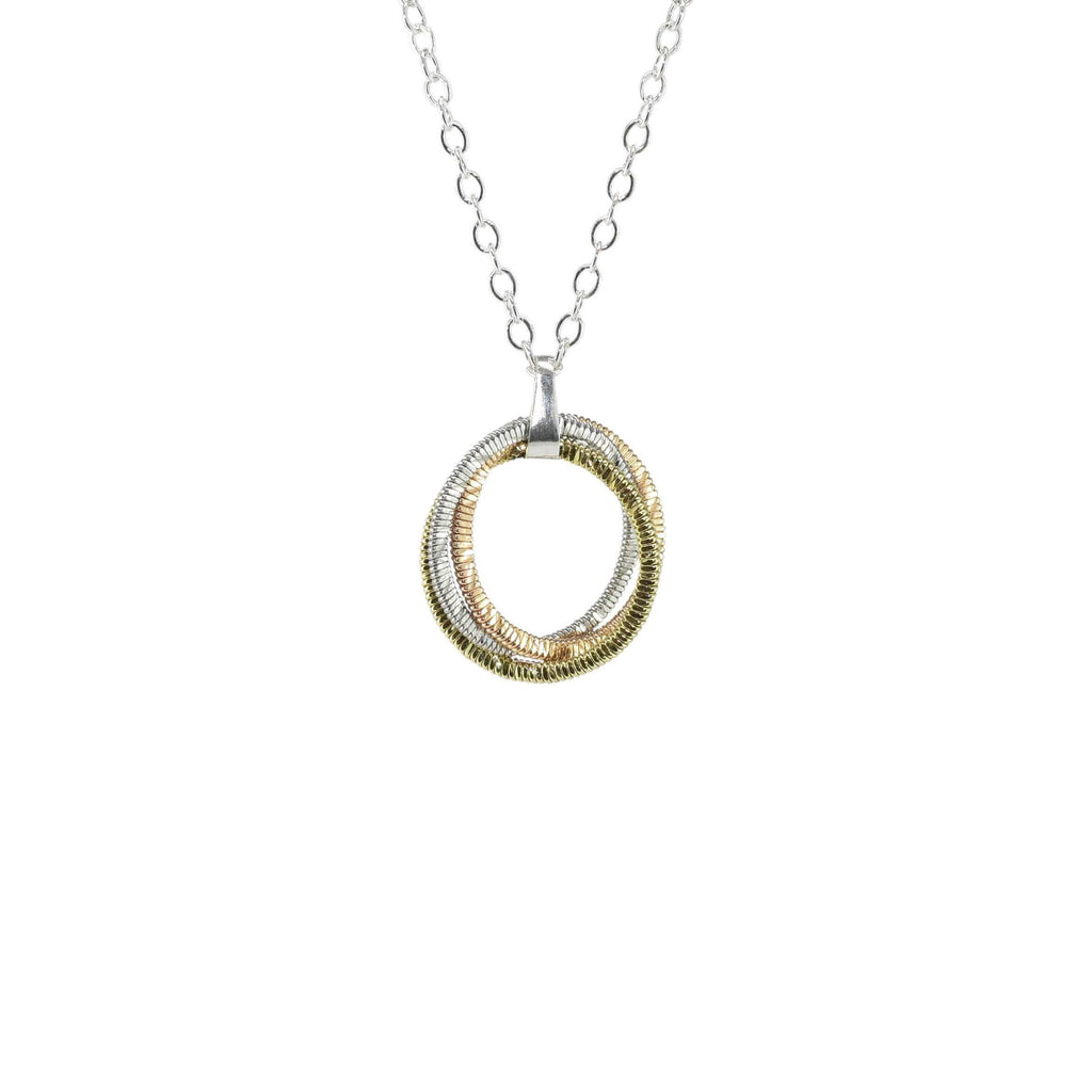 guitar string circular pendant on a silver chain suspended in a white background