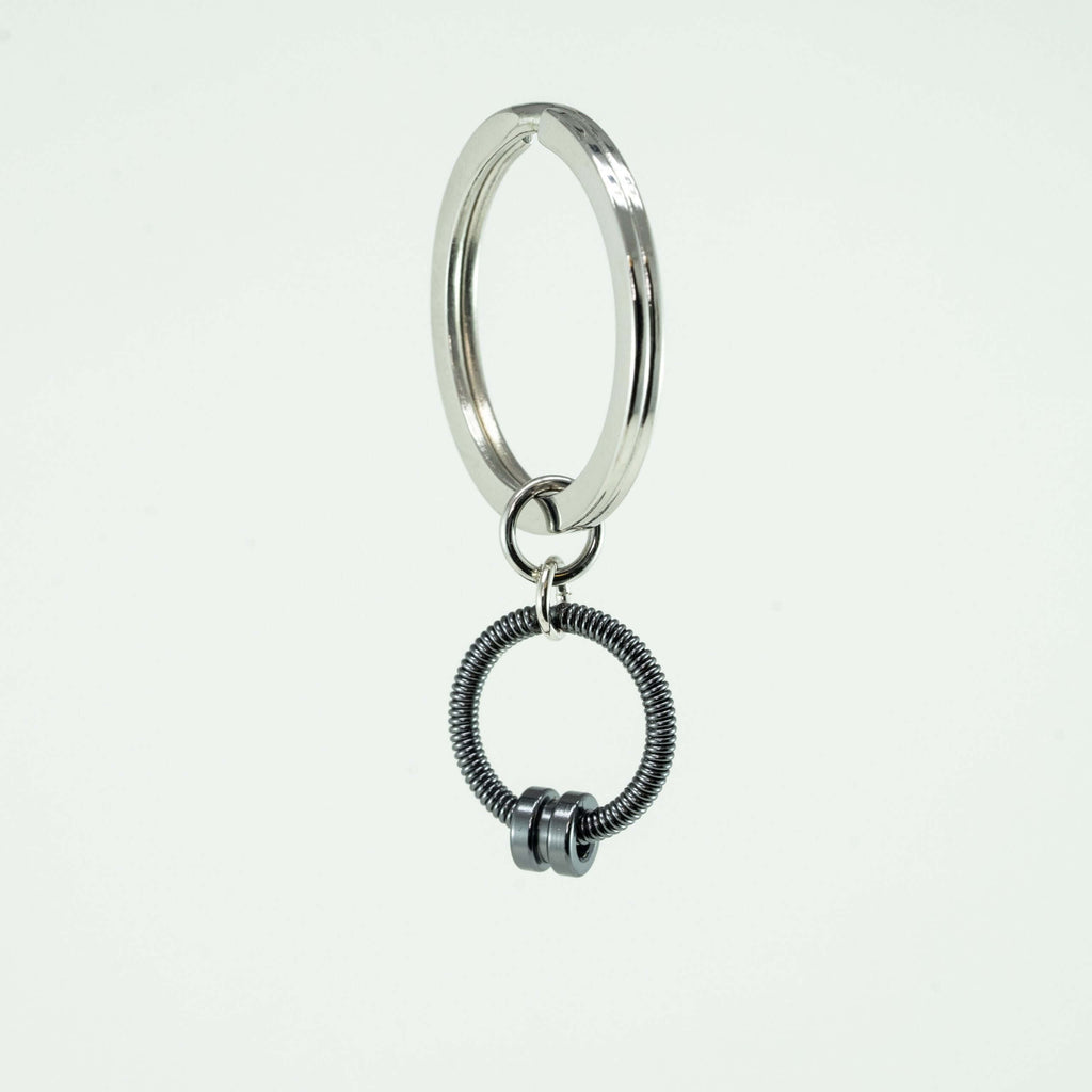 grey bass guitar string keychain on a white background
