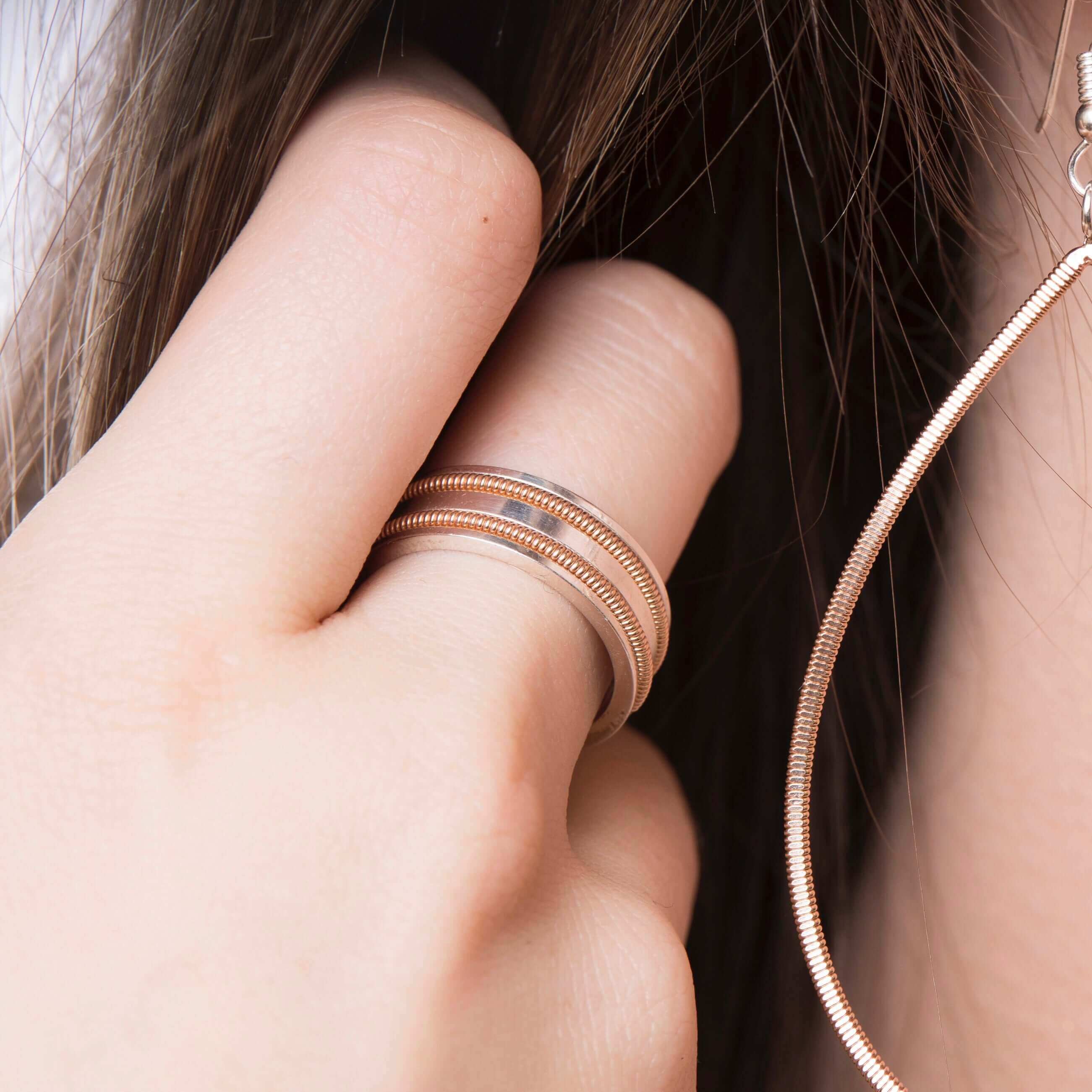 Close up of model wearing guitar string ring and earring