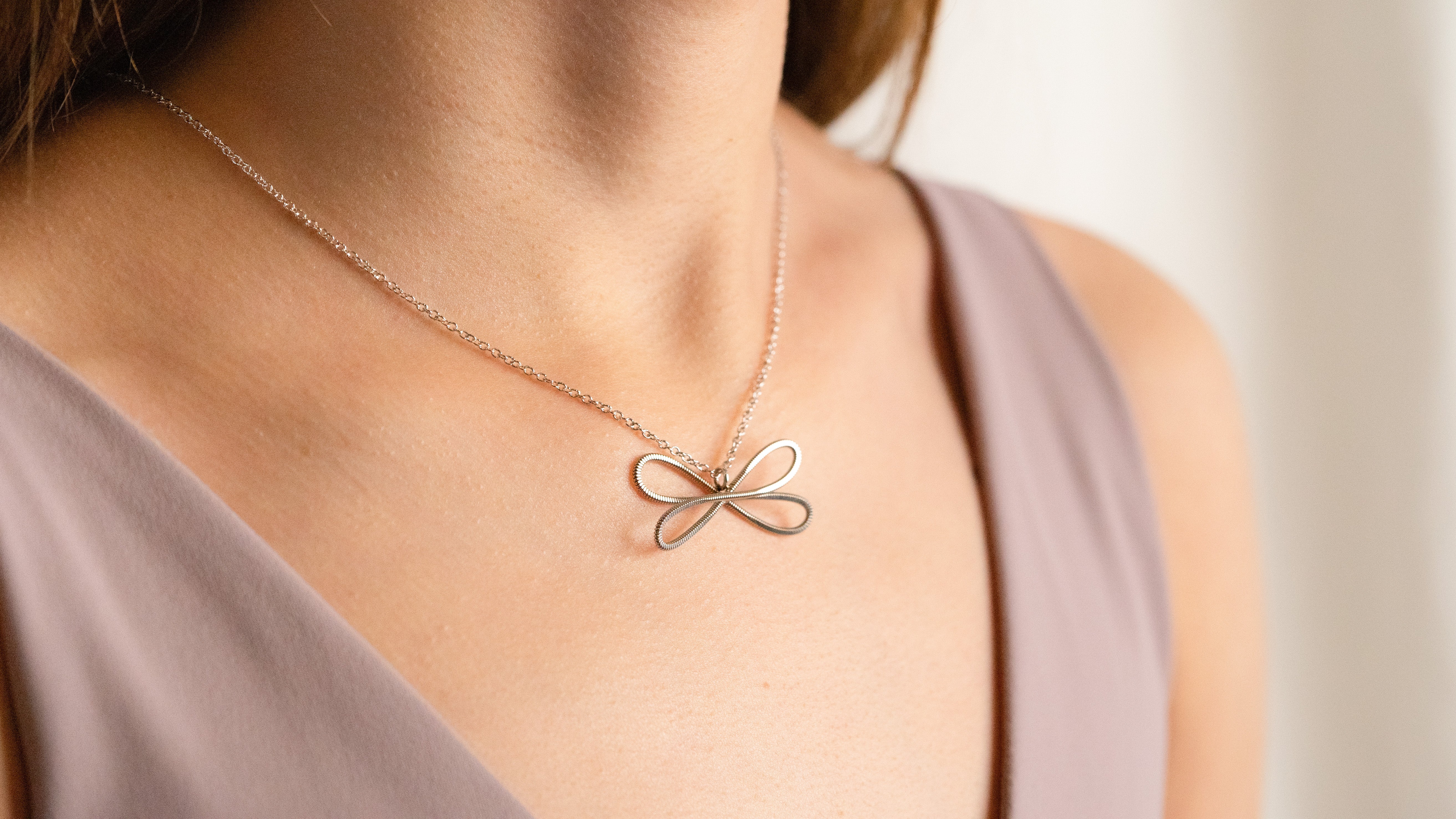 Guitar string heart necklace with aquamarine gemstone on black background
