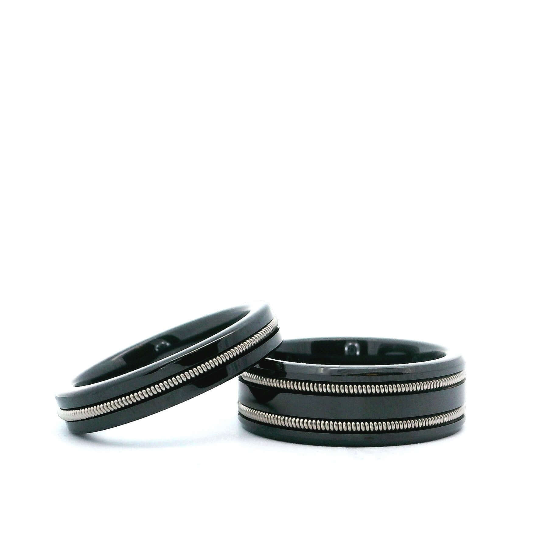 Black guitar string rings on white background