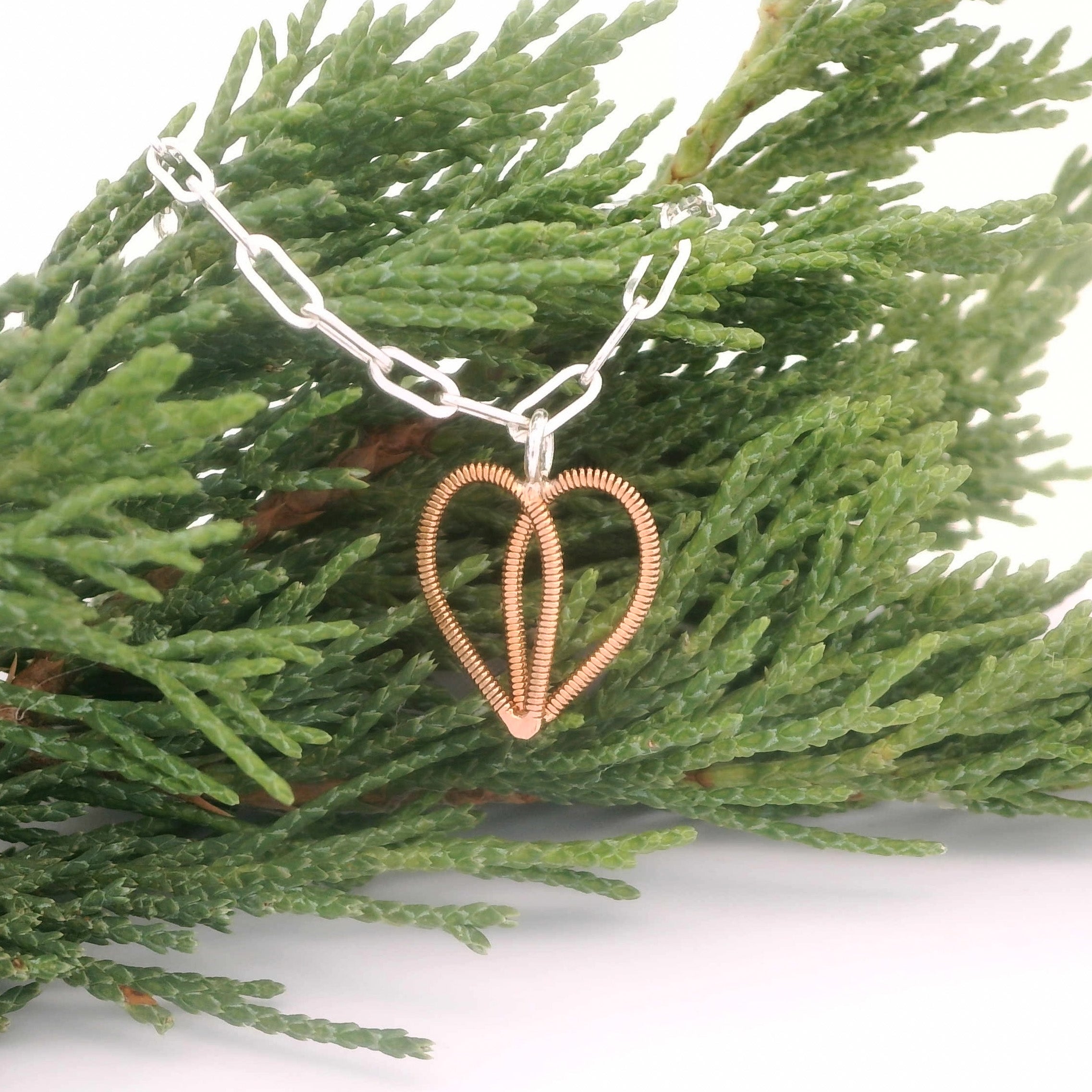 Silver paperclip chain bracelet with guitar string heart on pine branch