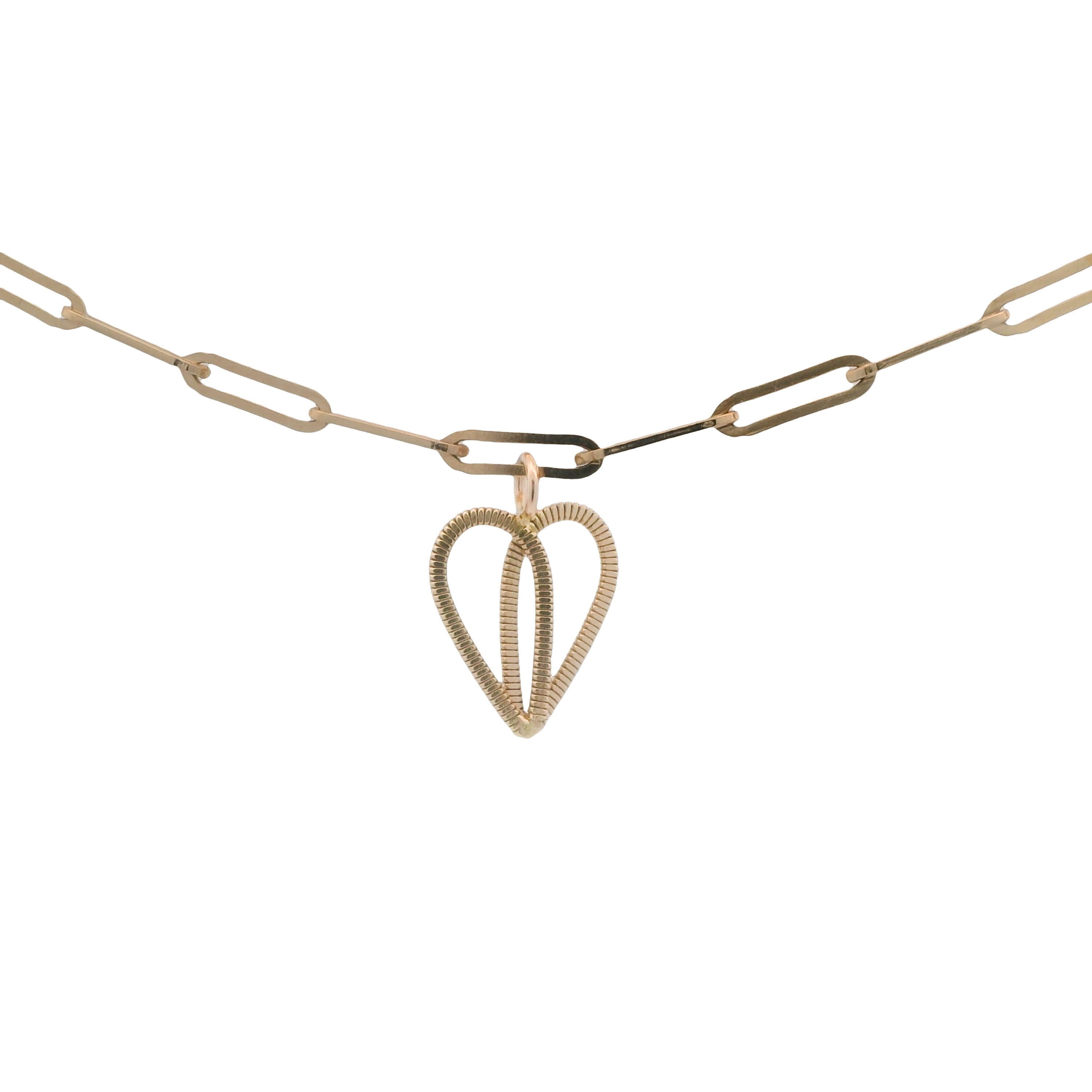 Gold guitar string heart on gold paperclip chain with white background.