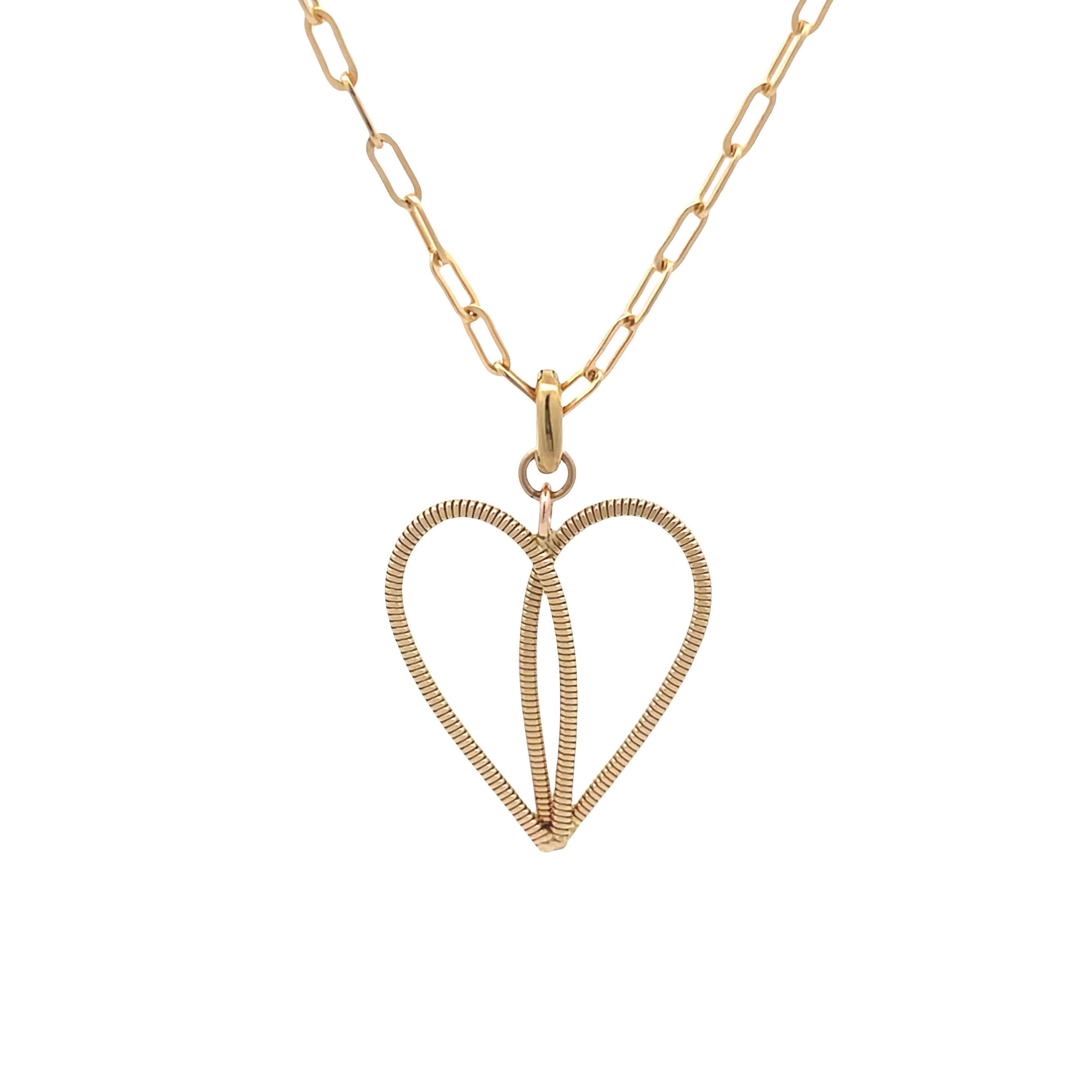Gold guitar string necklace on paperclip chain with a white background.