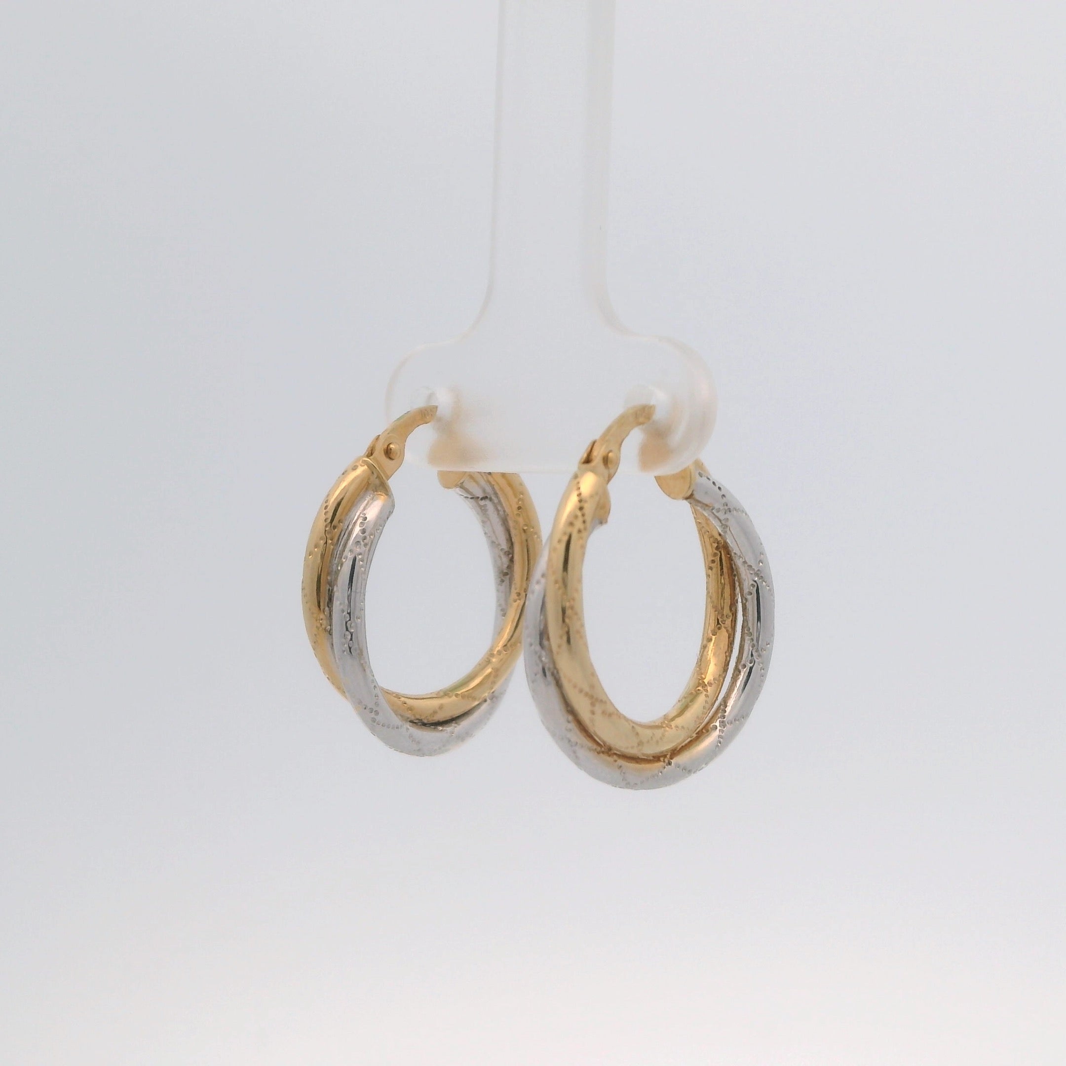 Two gold hoop earrings on a white background