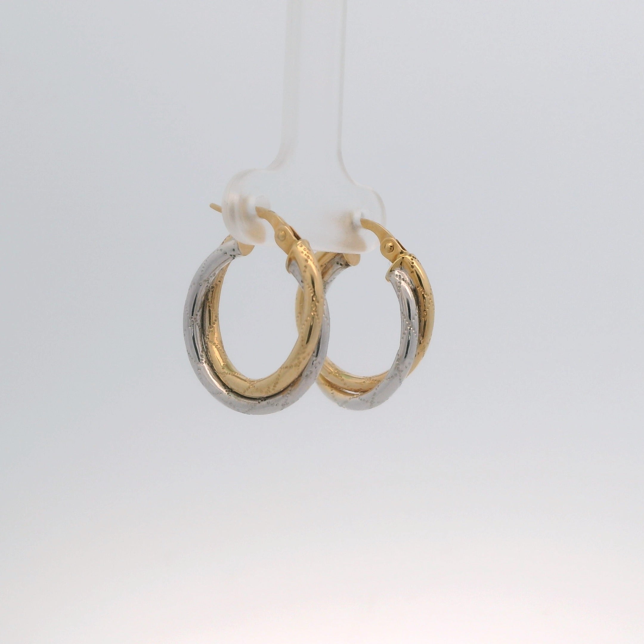 Two gold hoop earrings on a white background
