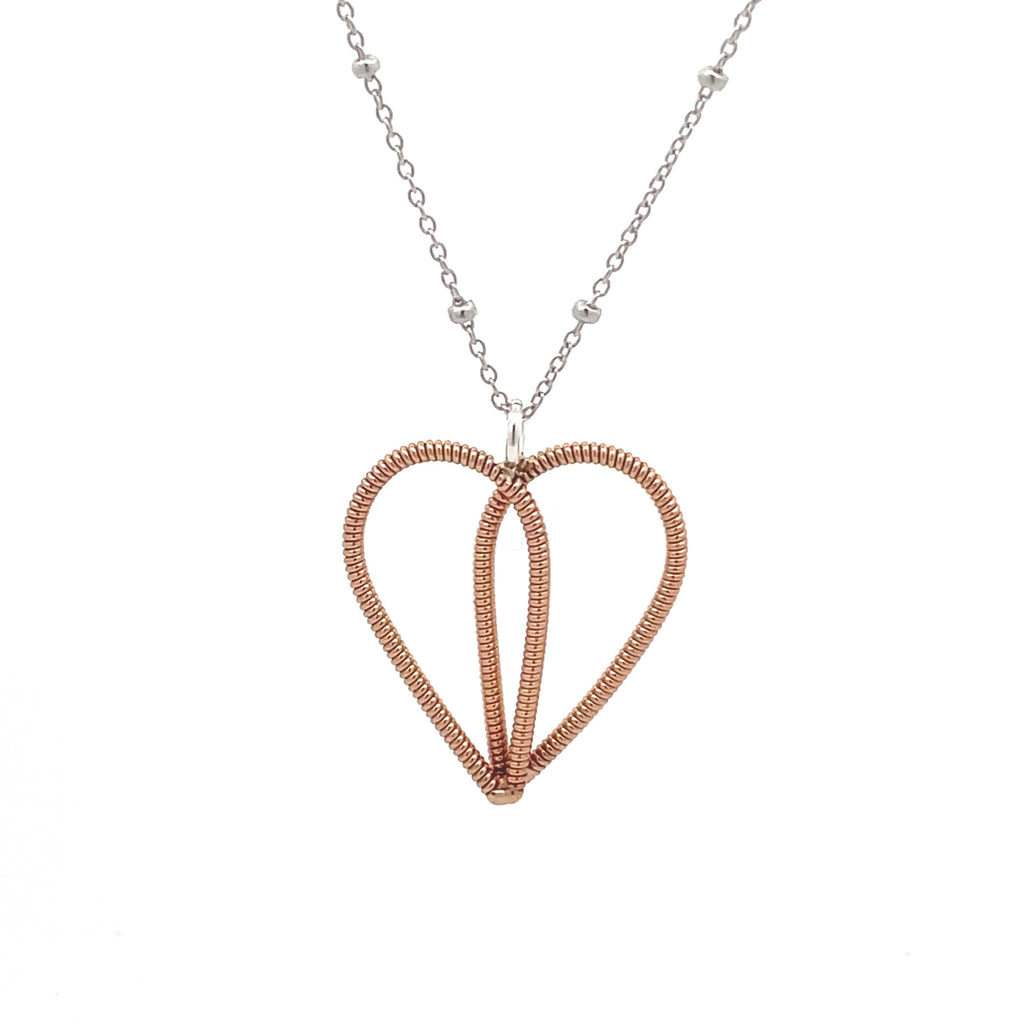 Heart necklace made with Sarah McLachlan 's guitar string on a white background