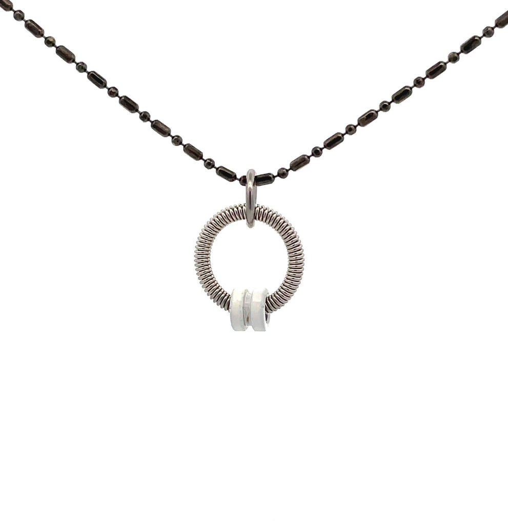 Bass guitar string necklace with white ball end and black chain on white background