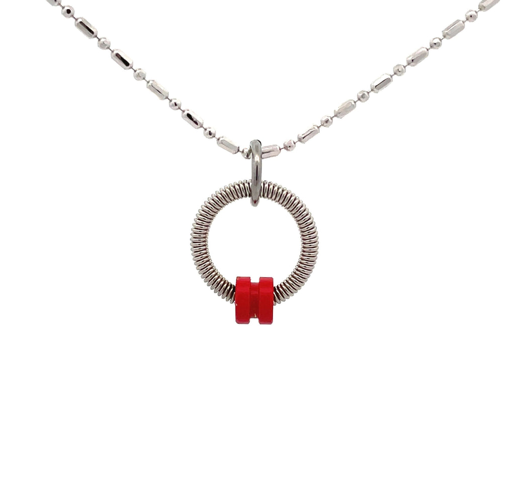 bass guitar string necklace with red ball end on white background