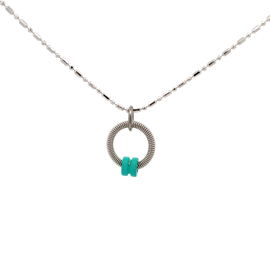 Bass guitar string necklace with turquoise ball end on white background