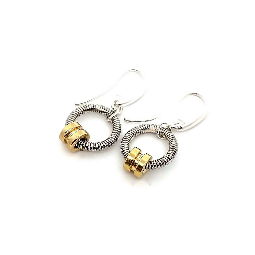 Bass guitar string earrings with brass ball ends on white background