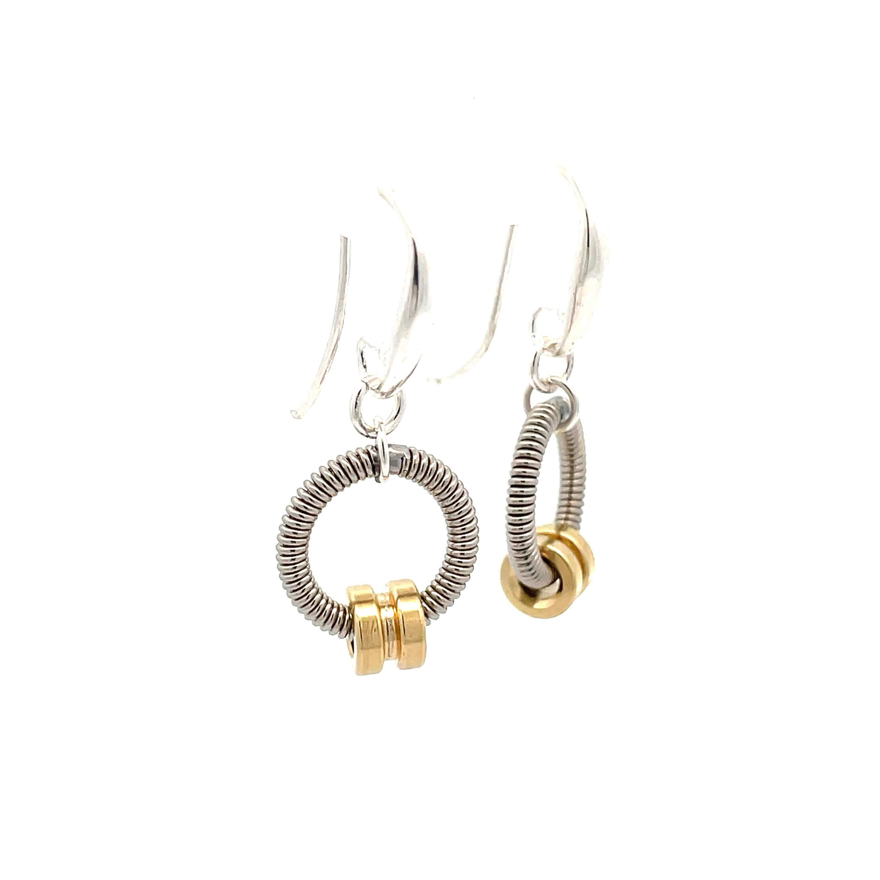 Bass guitar string earrings with brass ball ends on white background