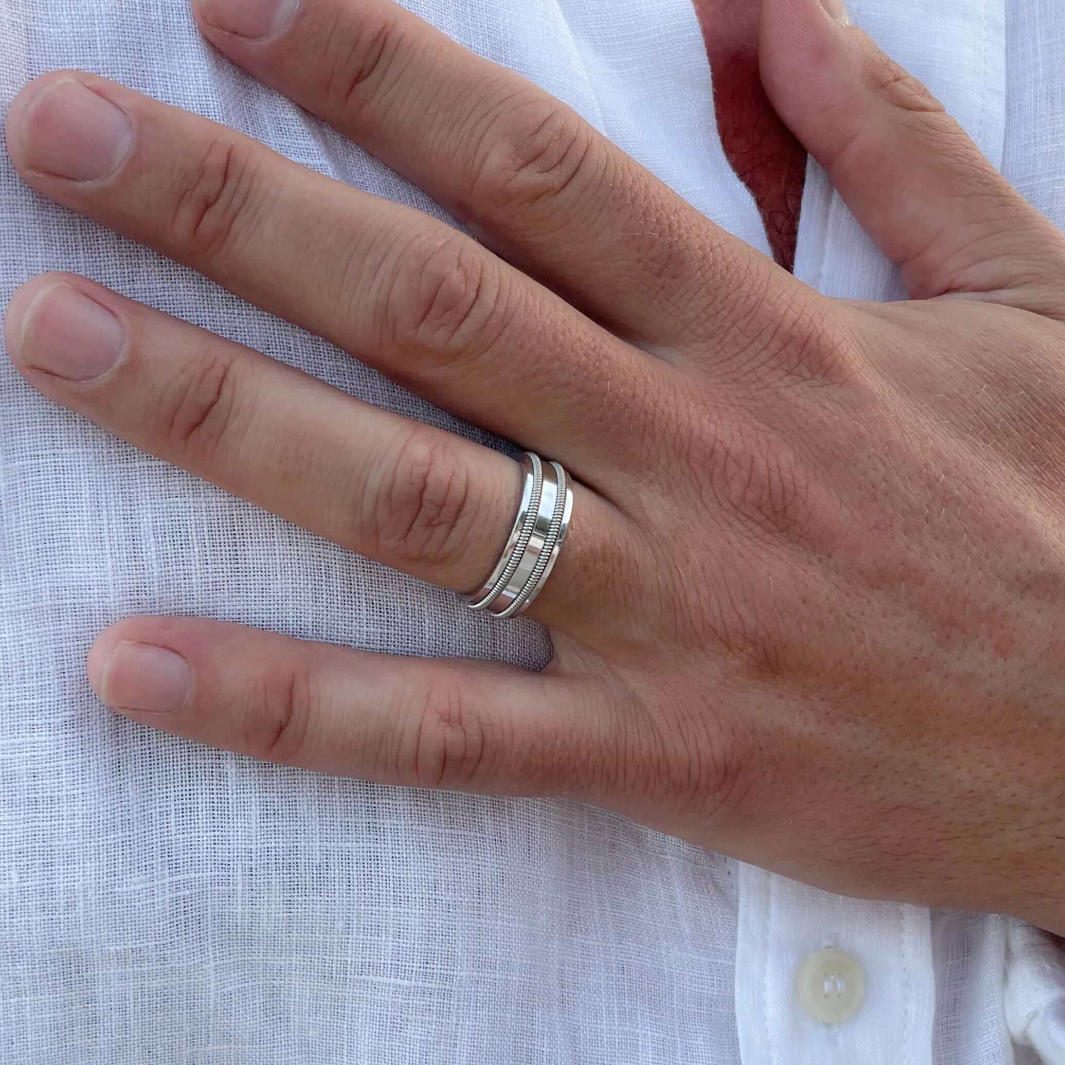 White gold guitar string ring on model with white shirt