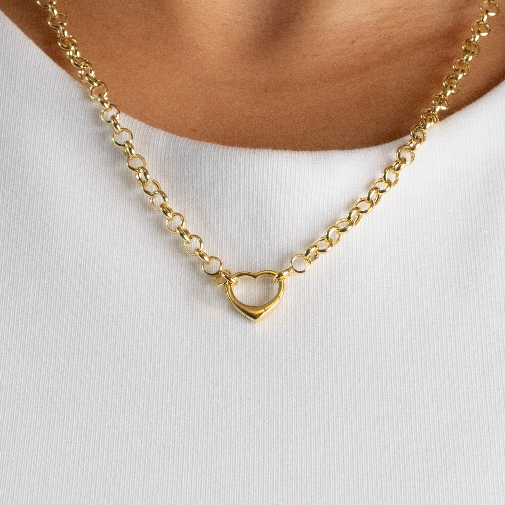 Gold necklace with a heart pendant on a white background