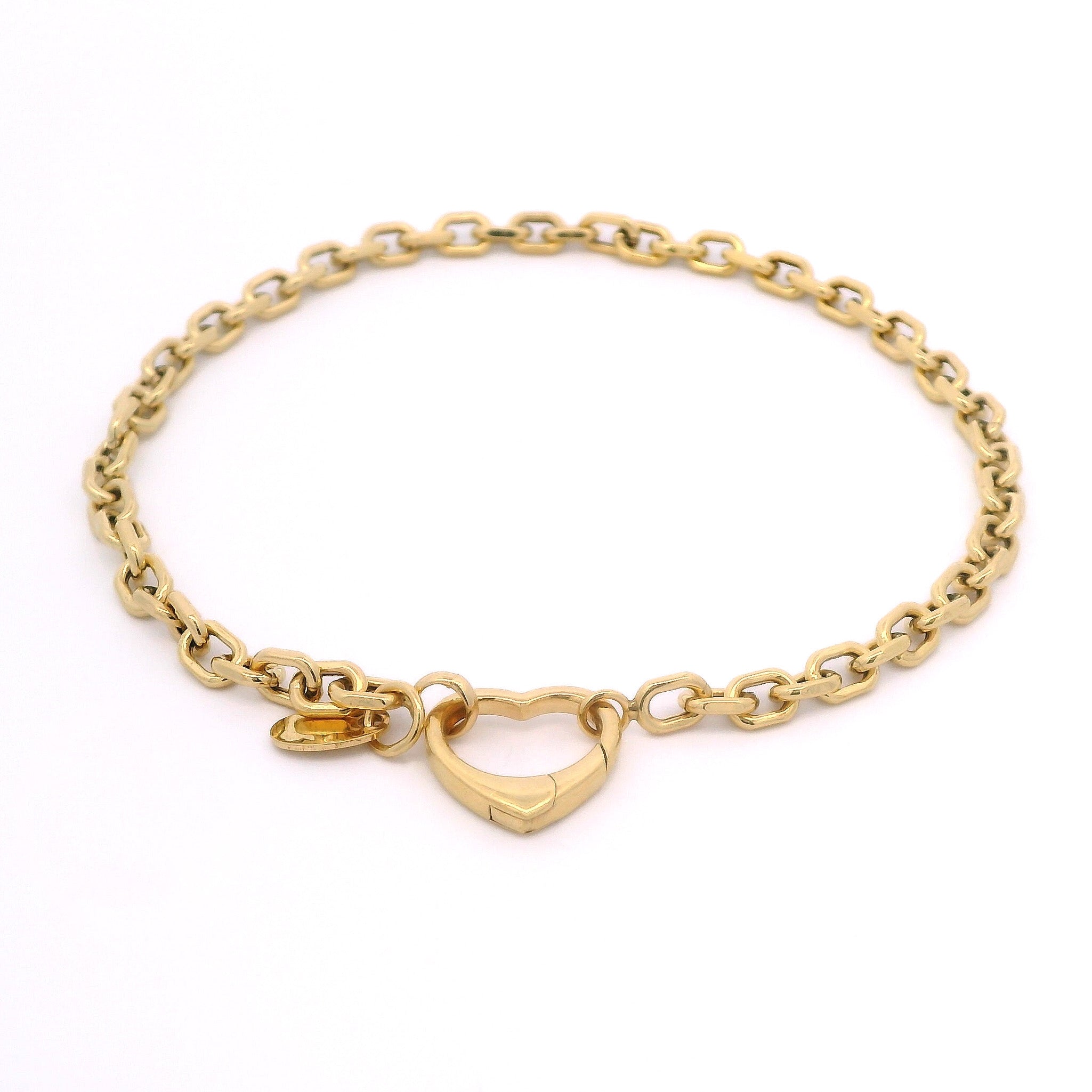 Gold chain bracelet with a heart-shaped clasp on a white background
