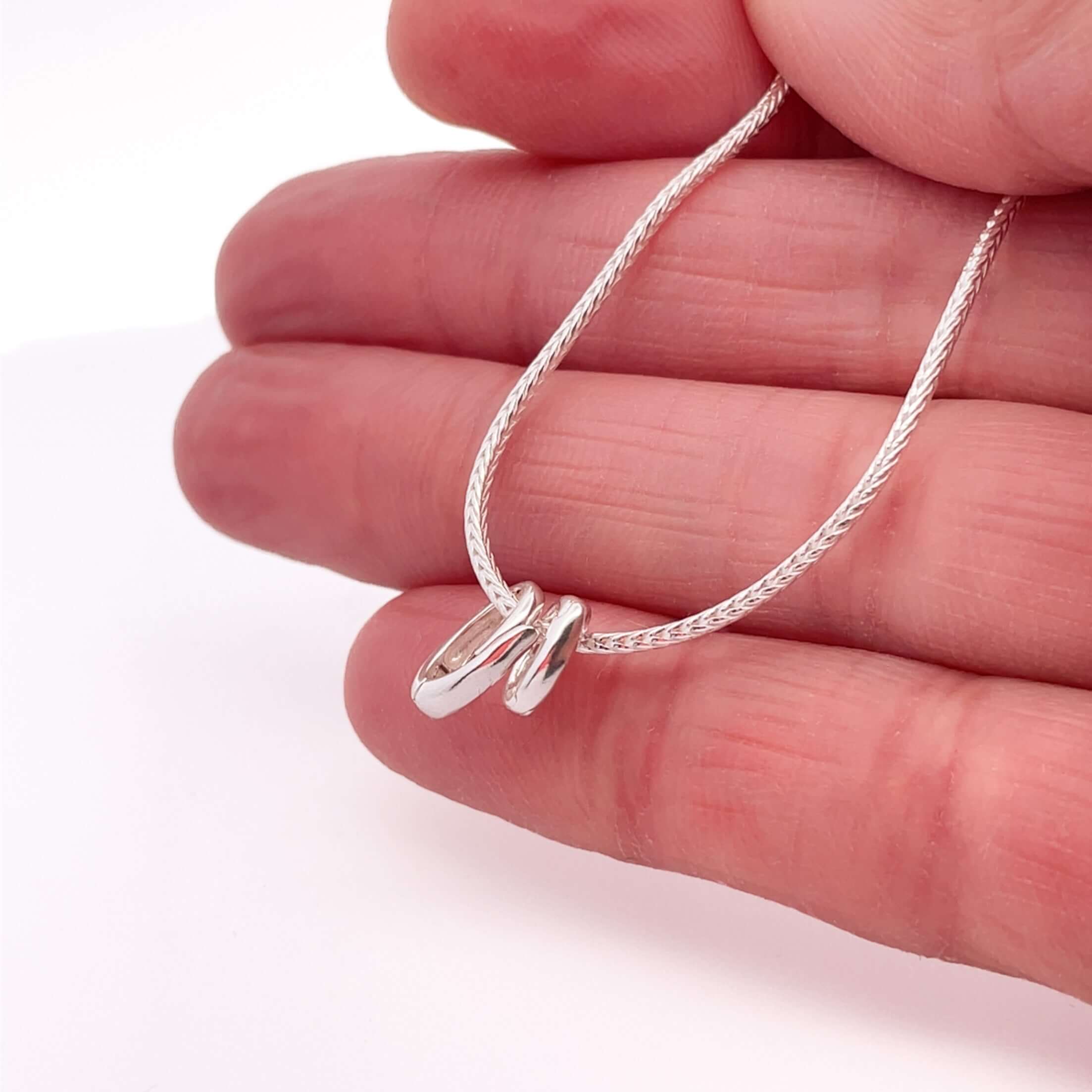 Silver foxtail chain with clasps on hand with white background