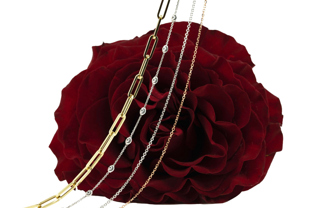 Solid gold chains in front to red rose