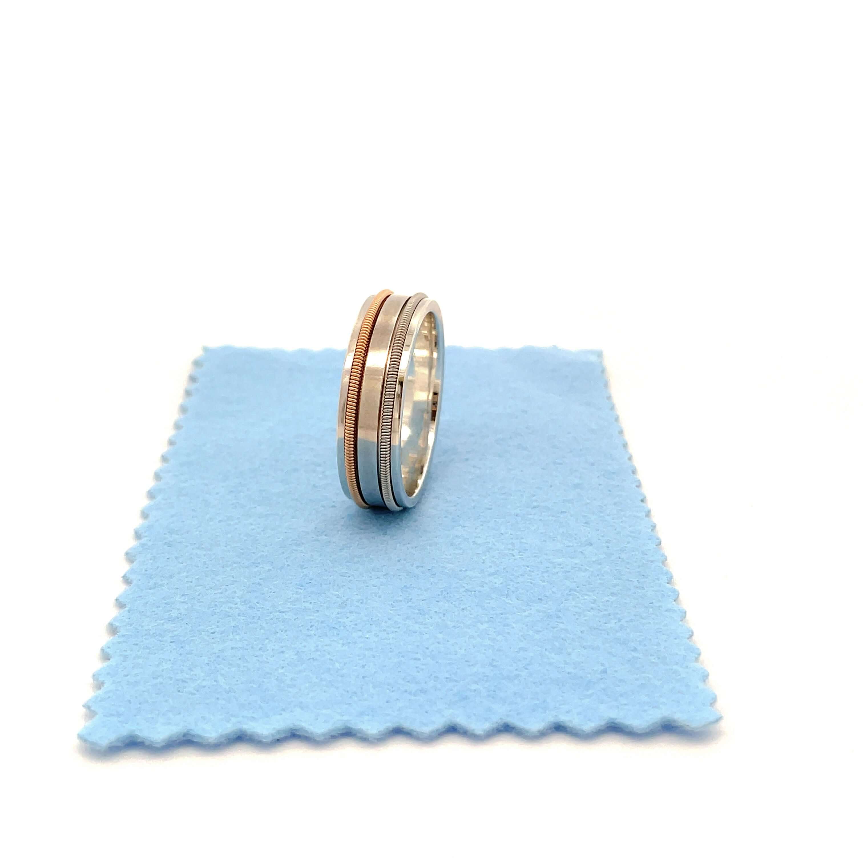 guitar string silver ring on a blue polishing cloth