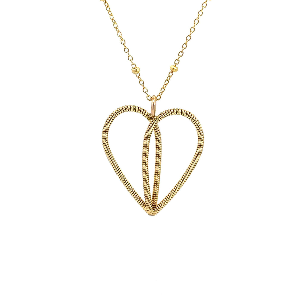 Gold guitar string heart necklace on a white background.