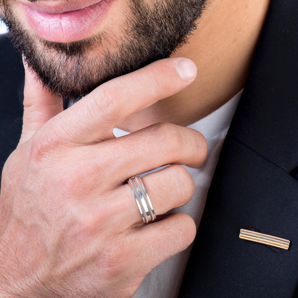 Close up of guitar string ring on male model