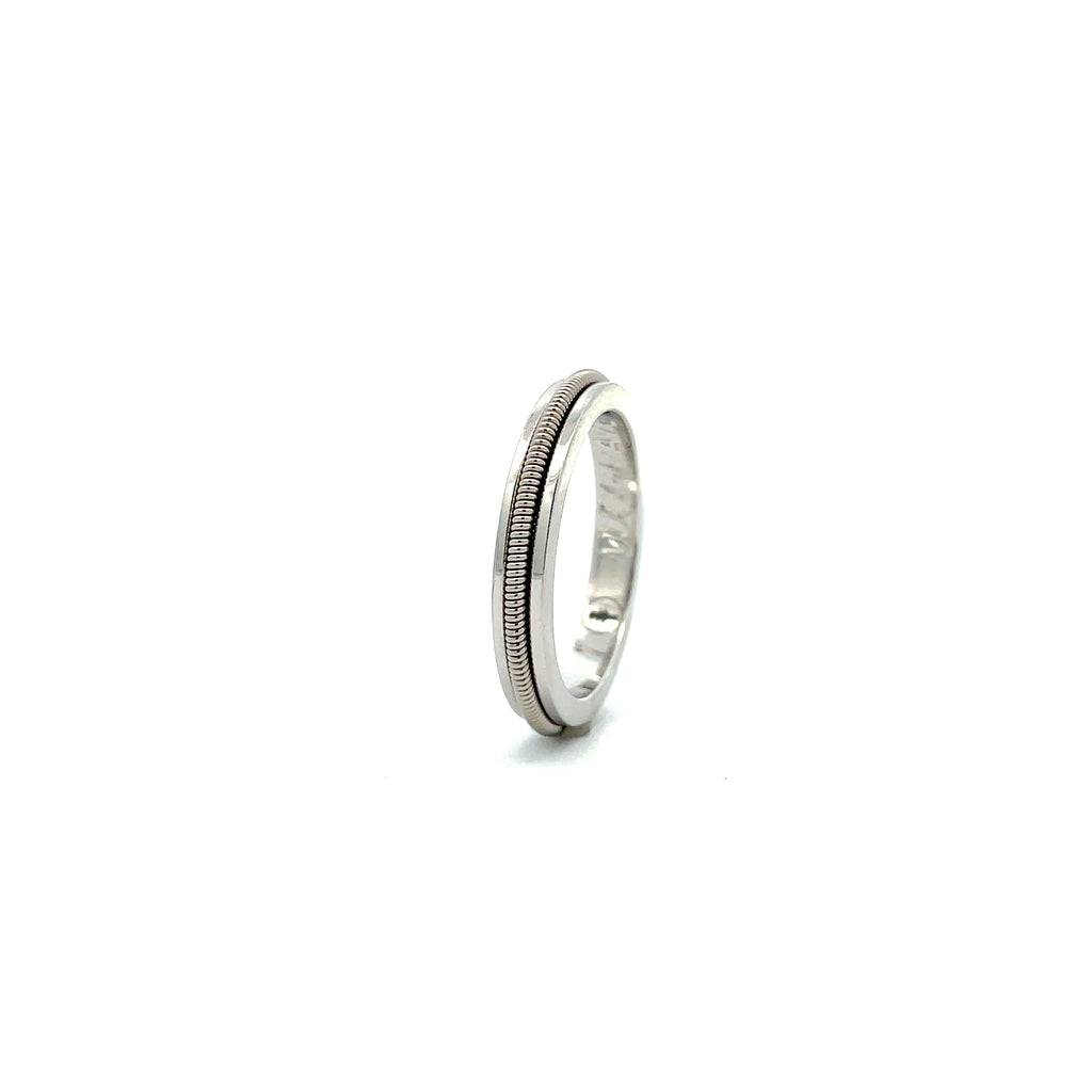silver and electric guitar string ring on a white background 