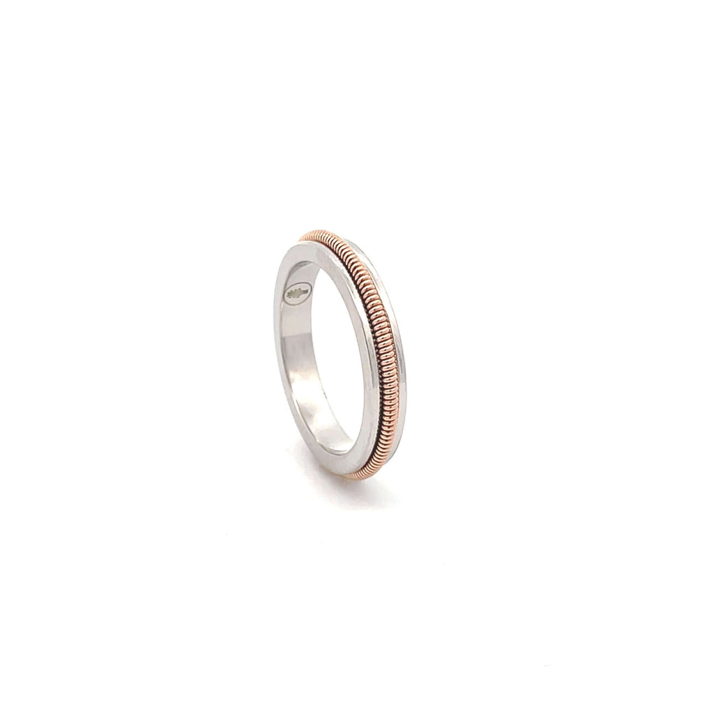 Silver guitar string ring with one inlaid acoustic string on white background