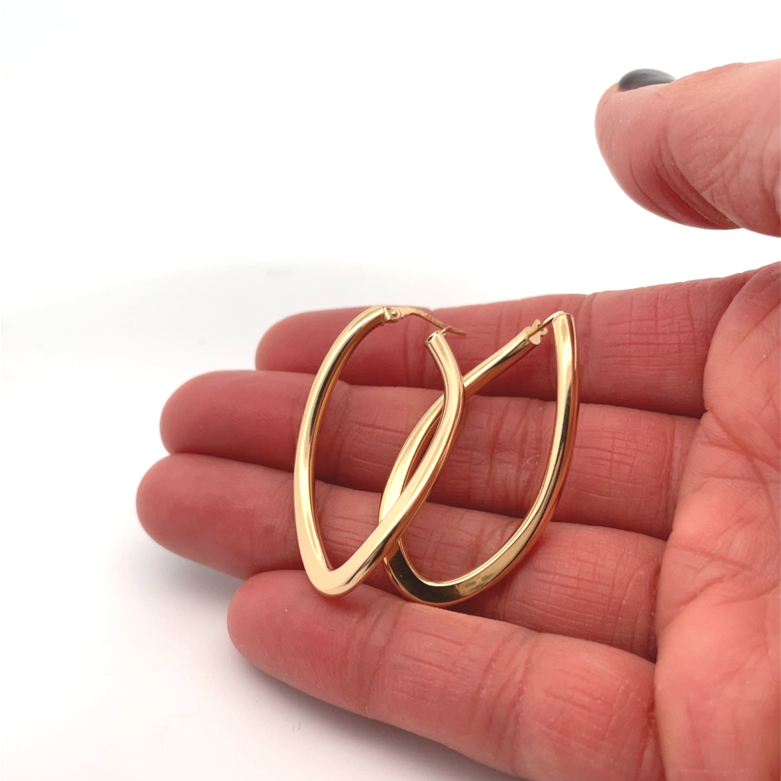 curved gold hoops on hand