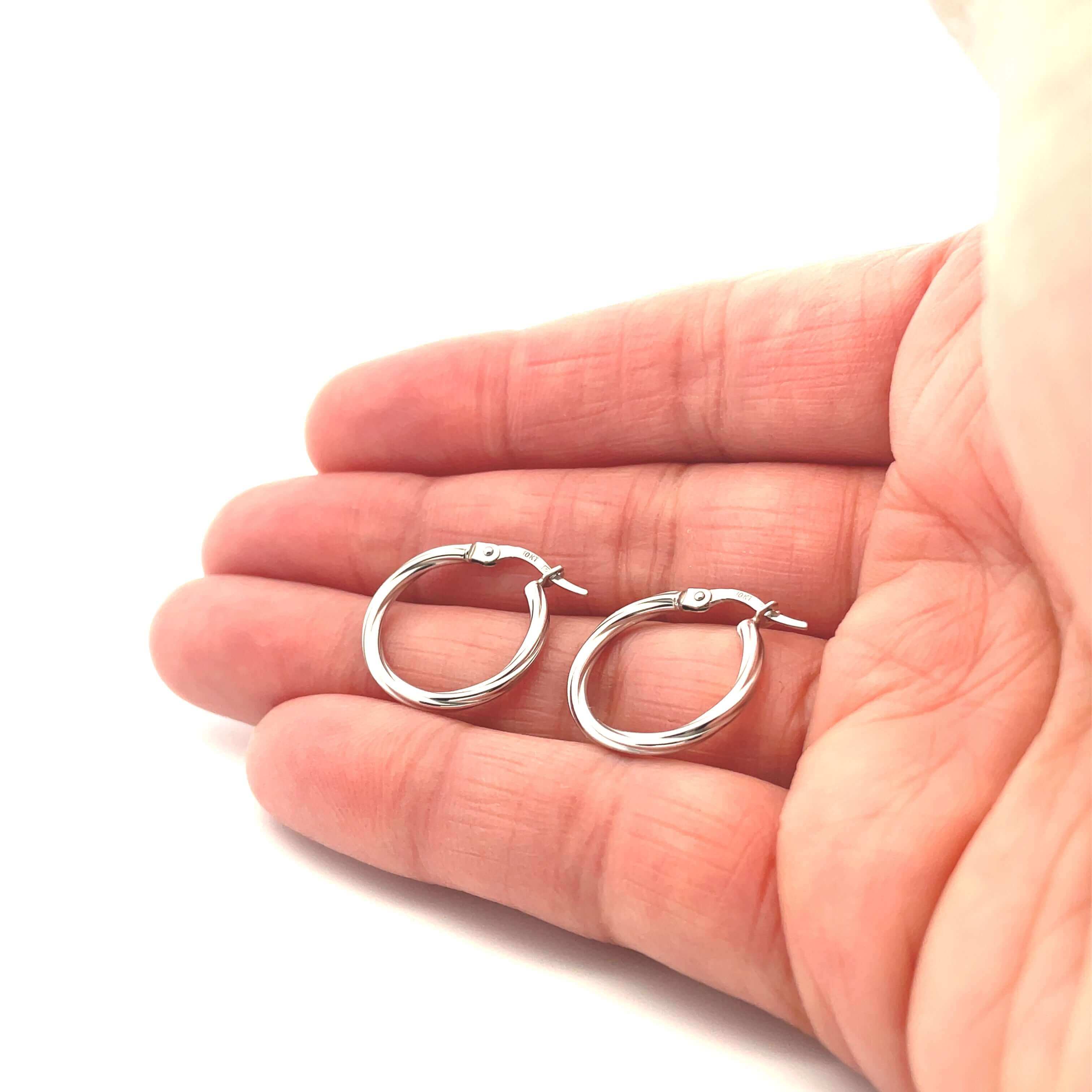 white gold twist hoop earrings on hand