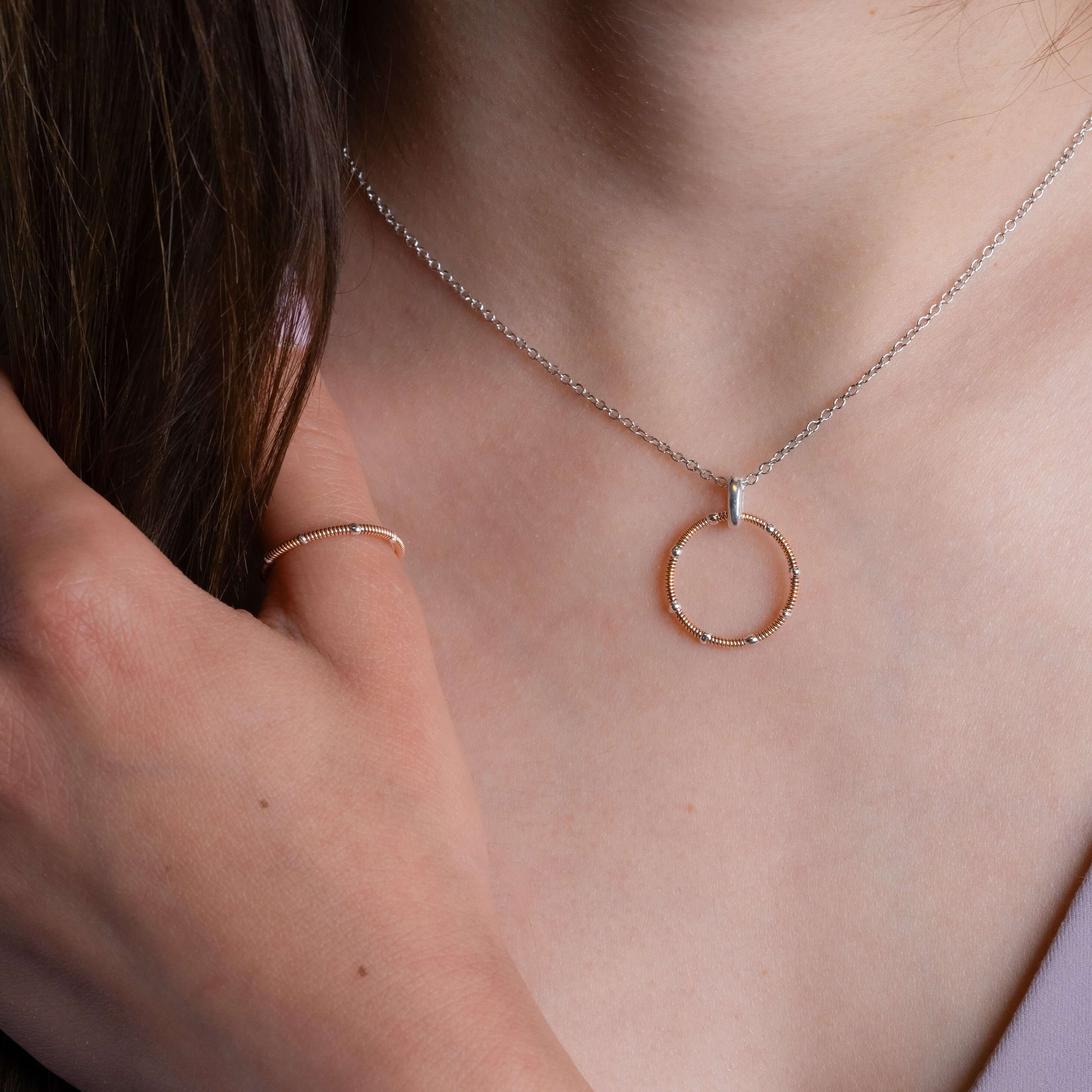 Rose gold guitar string ring and necklace on model