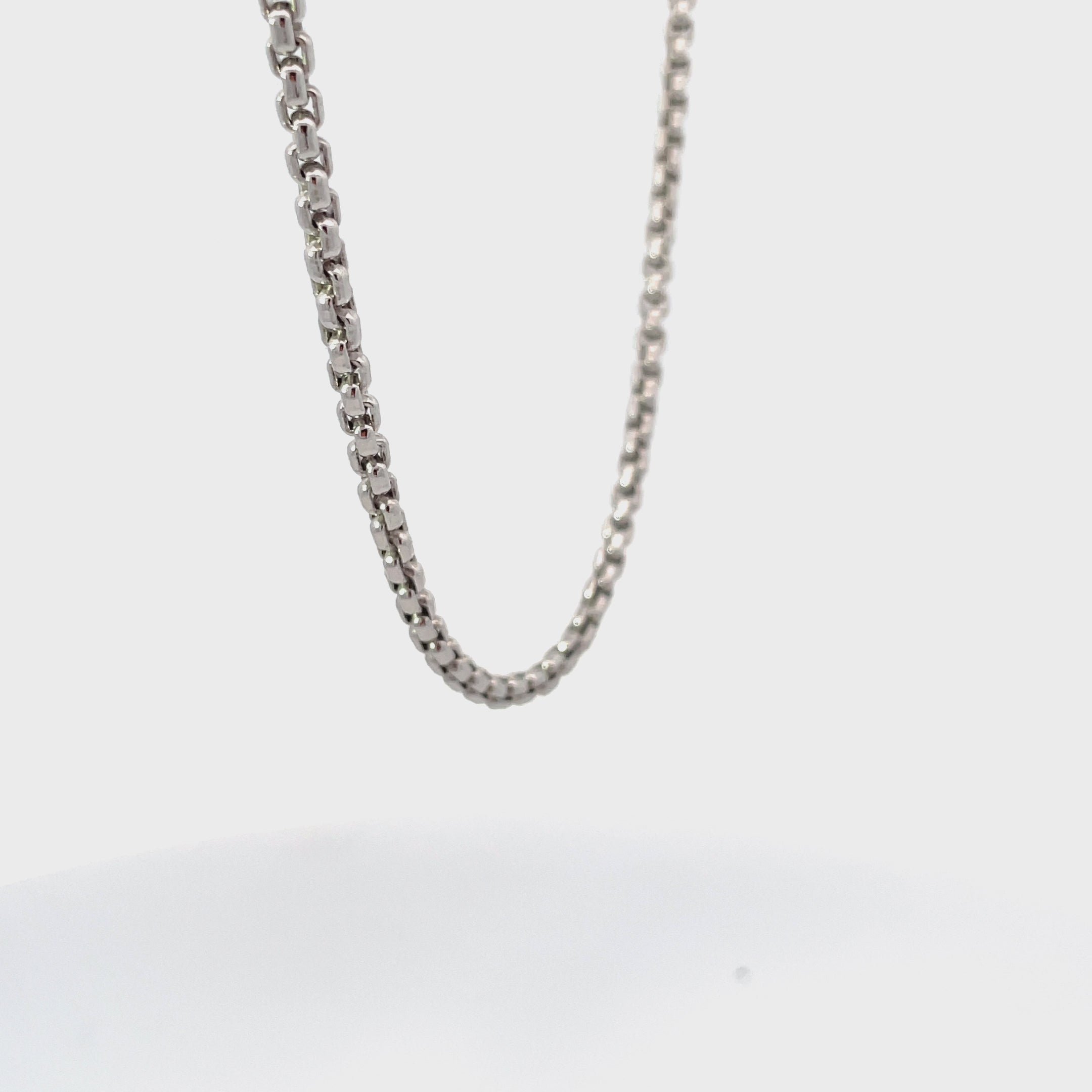 Silver round box chain rotating on white background.