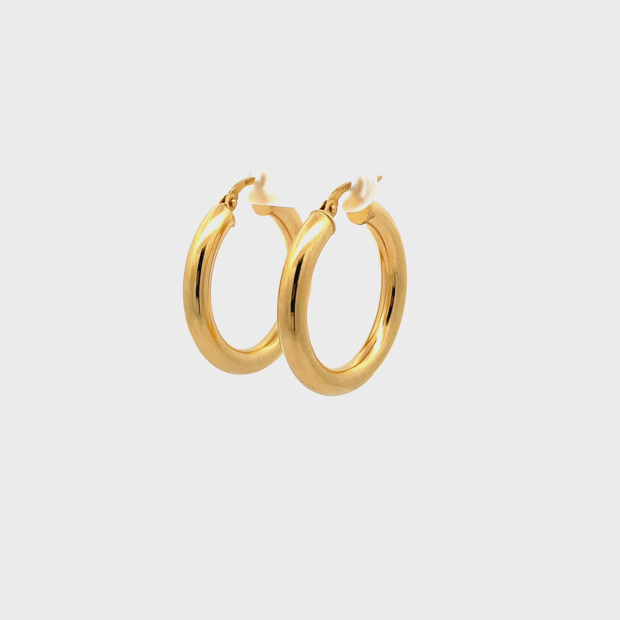 Large gold tube-style hoop earrings rotating on a white background