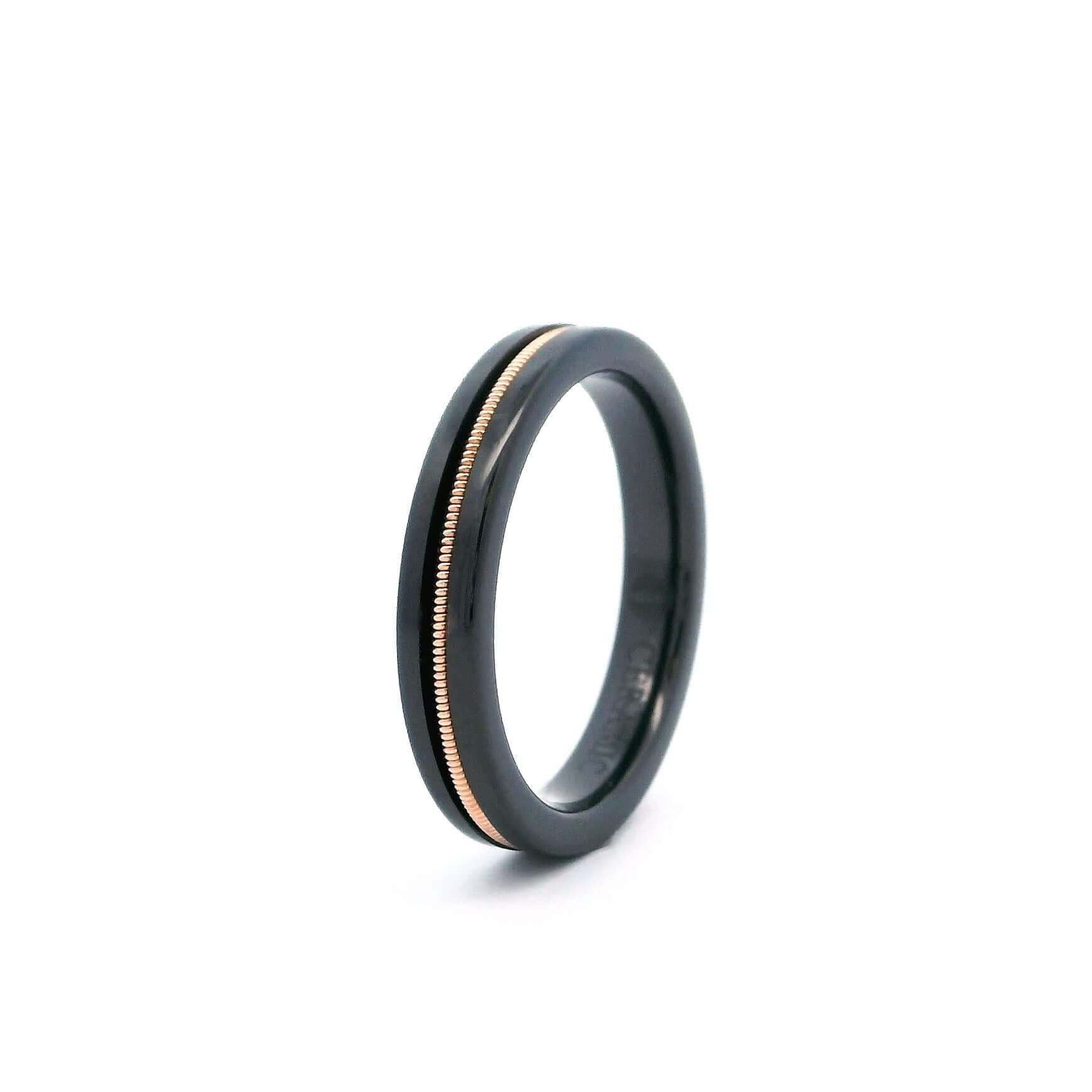 Black ring embedded with bronze guitar string on a white background