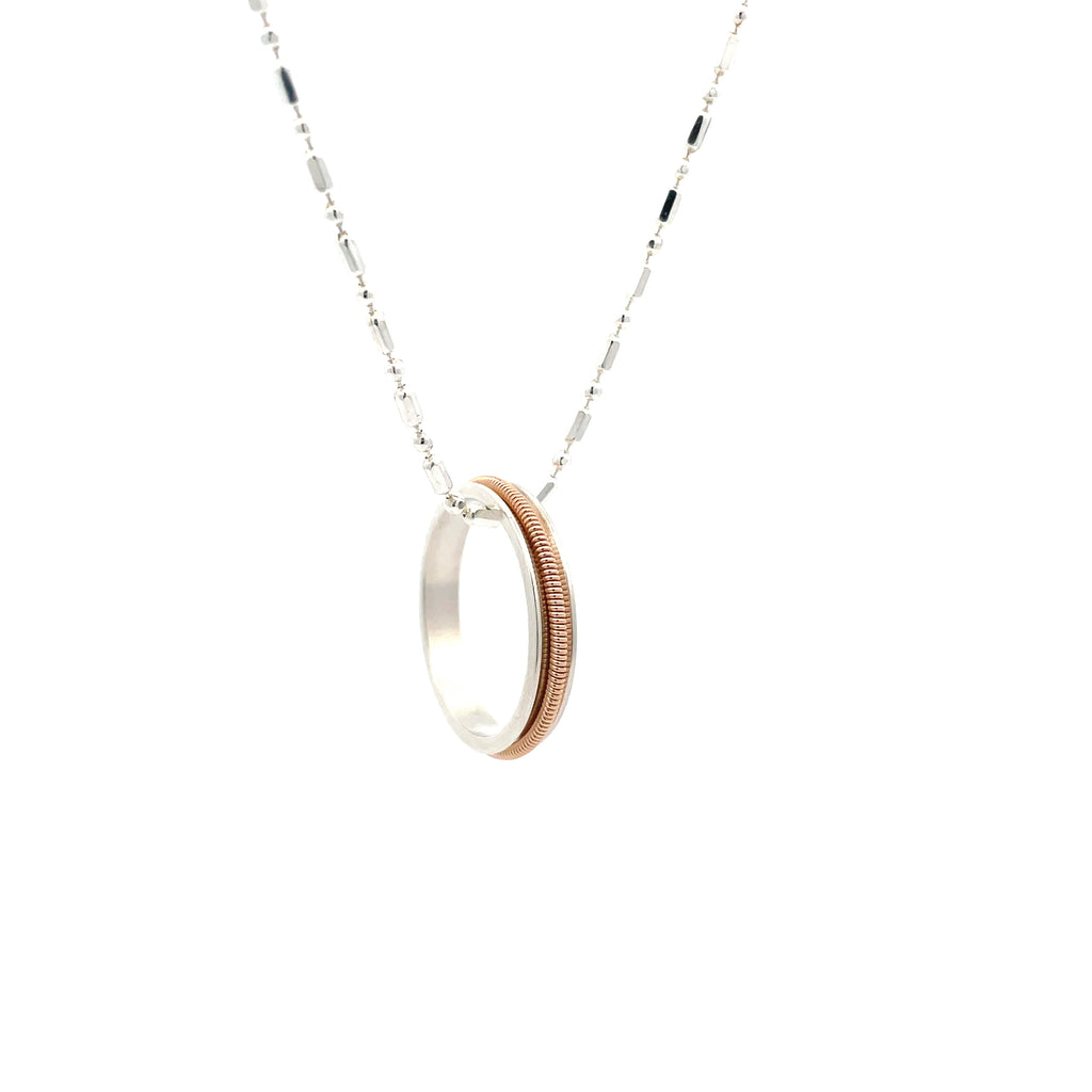 guitar string ring necklace with silver chain on white background