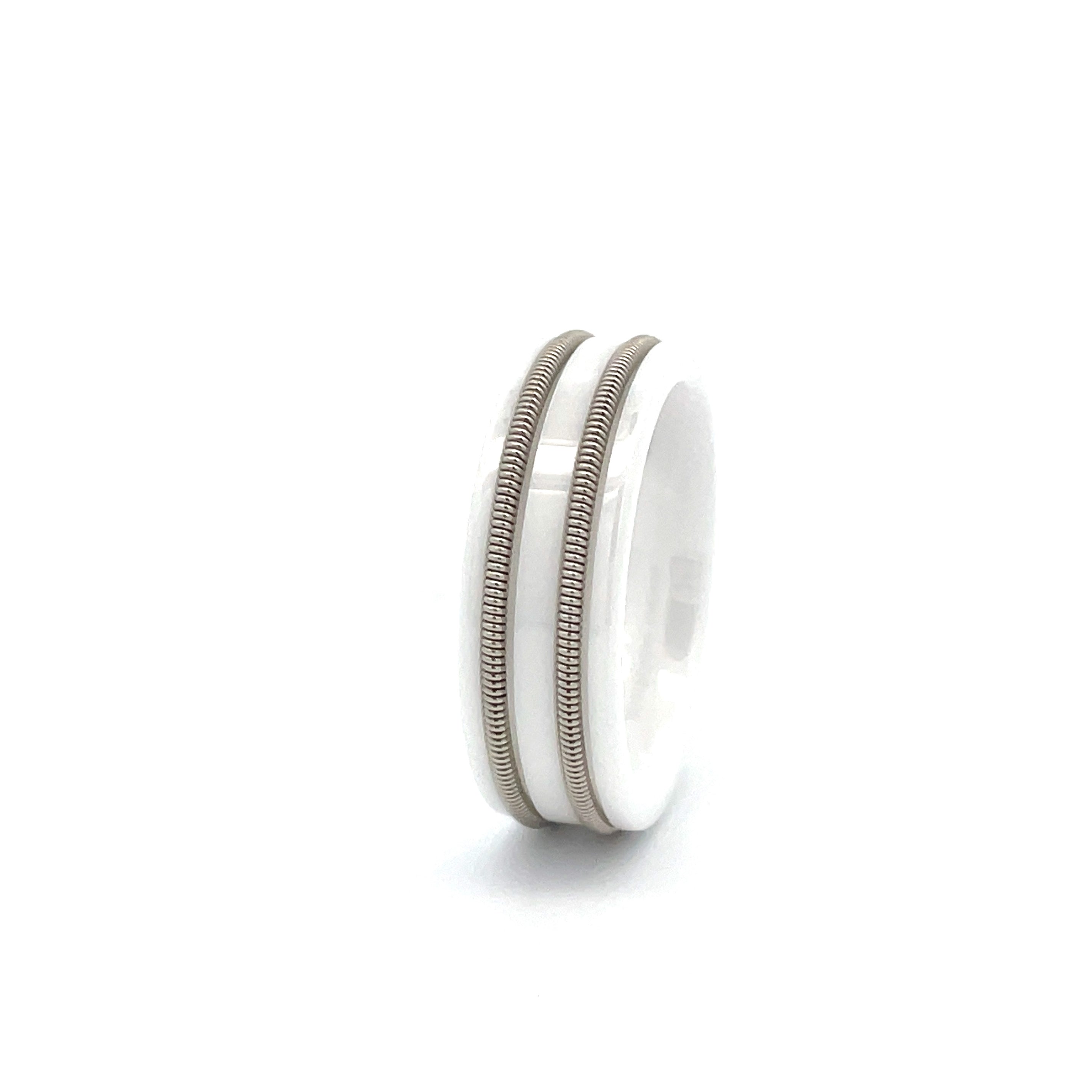 White ring with embedded electric guitar string on white background.