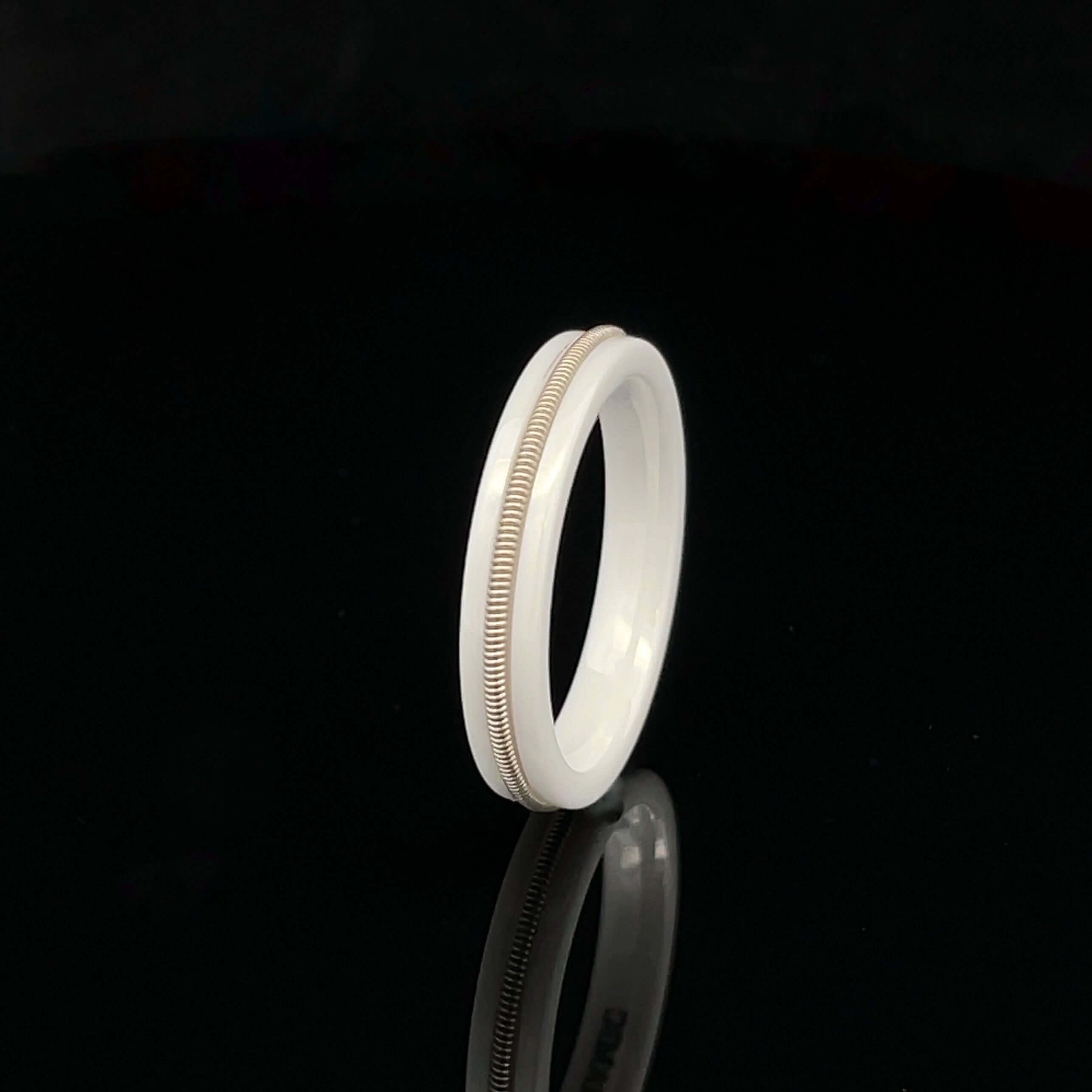 white guitar string ring on black background