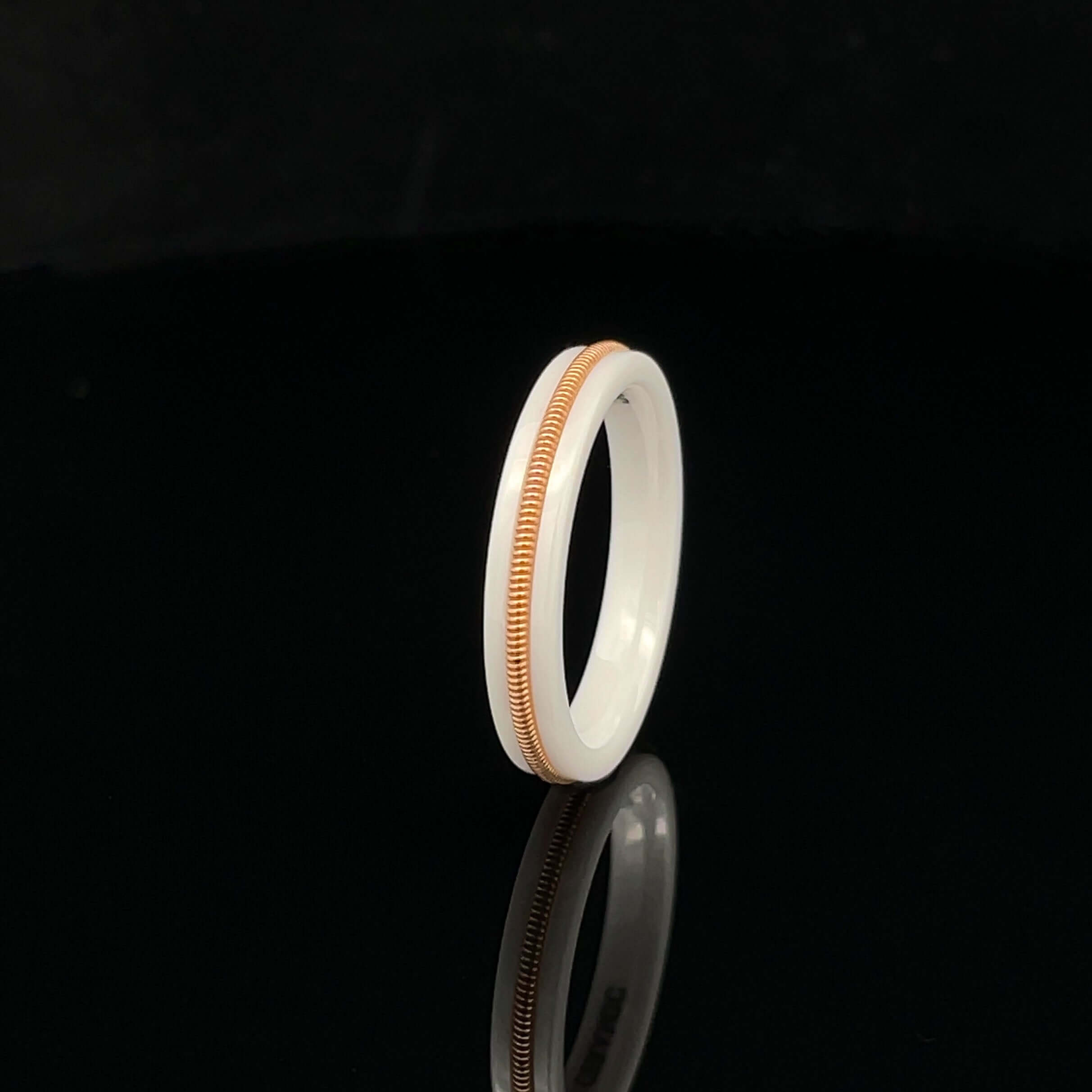 White luminous ring with embedded bronze guitar string on a black background.