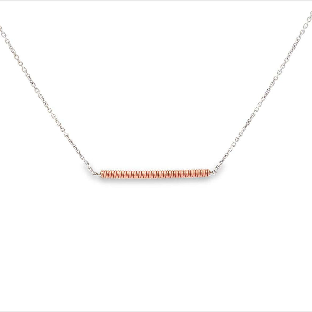 Piano string and white gold necklace on a whit background