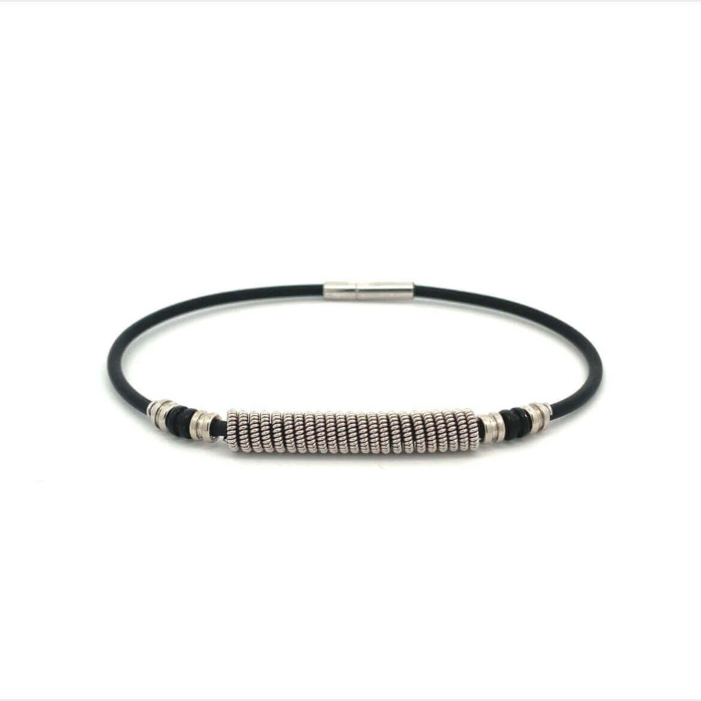Black electric guitar string bracelet with silver and black guitar ball ends on white background