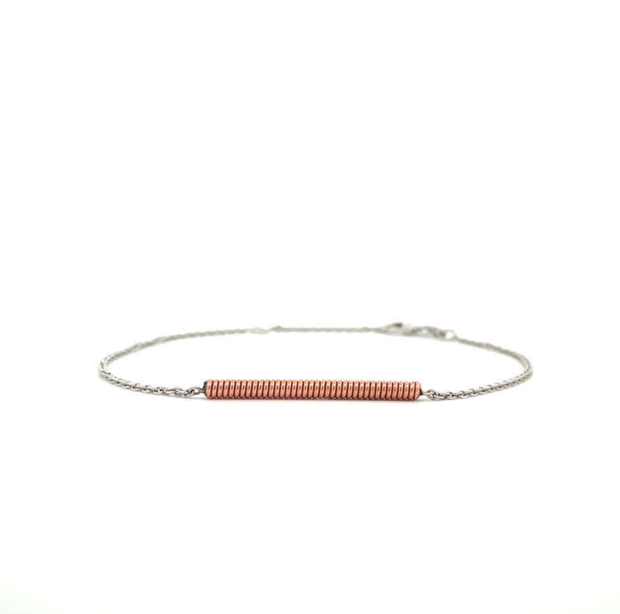 Piano string and white gold bracelet on a white background