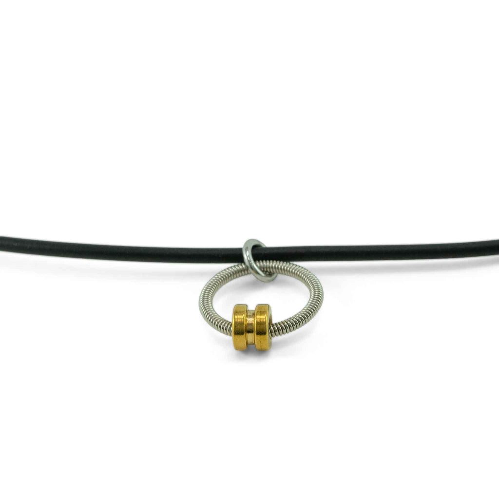 bass guitar string necklace with gold ball end and black lacing hanging on white background