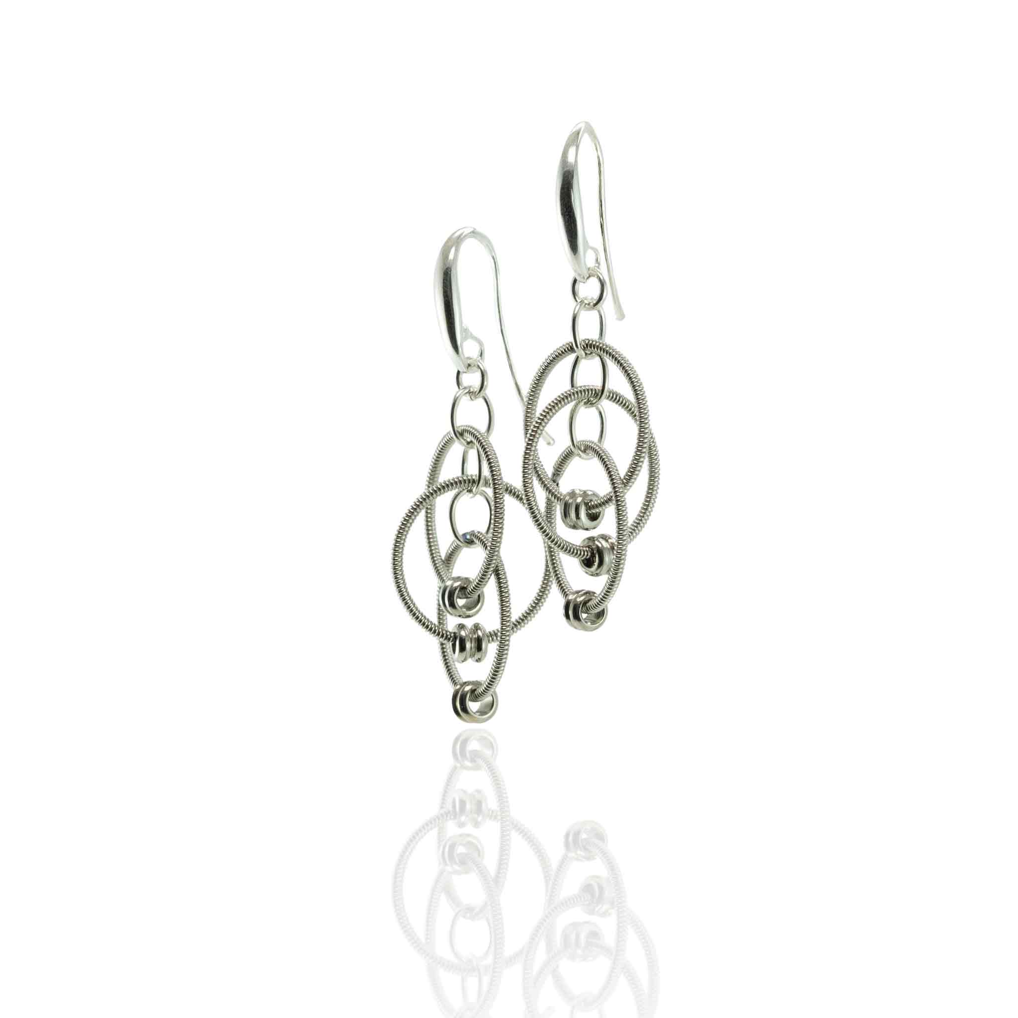 Electric guitar string multiple dangling loop earrings hanging on white background.