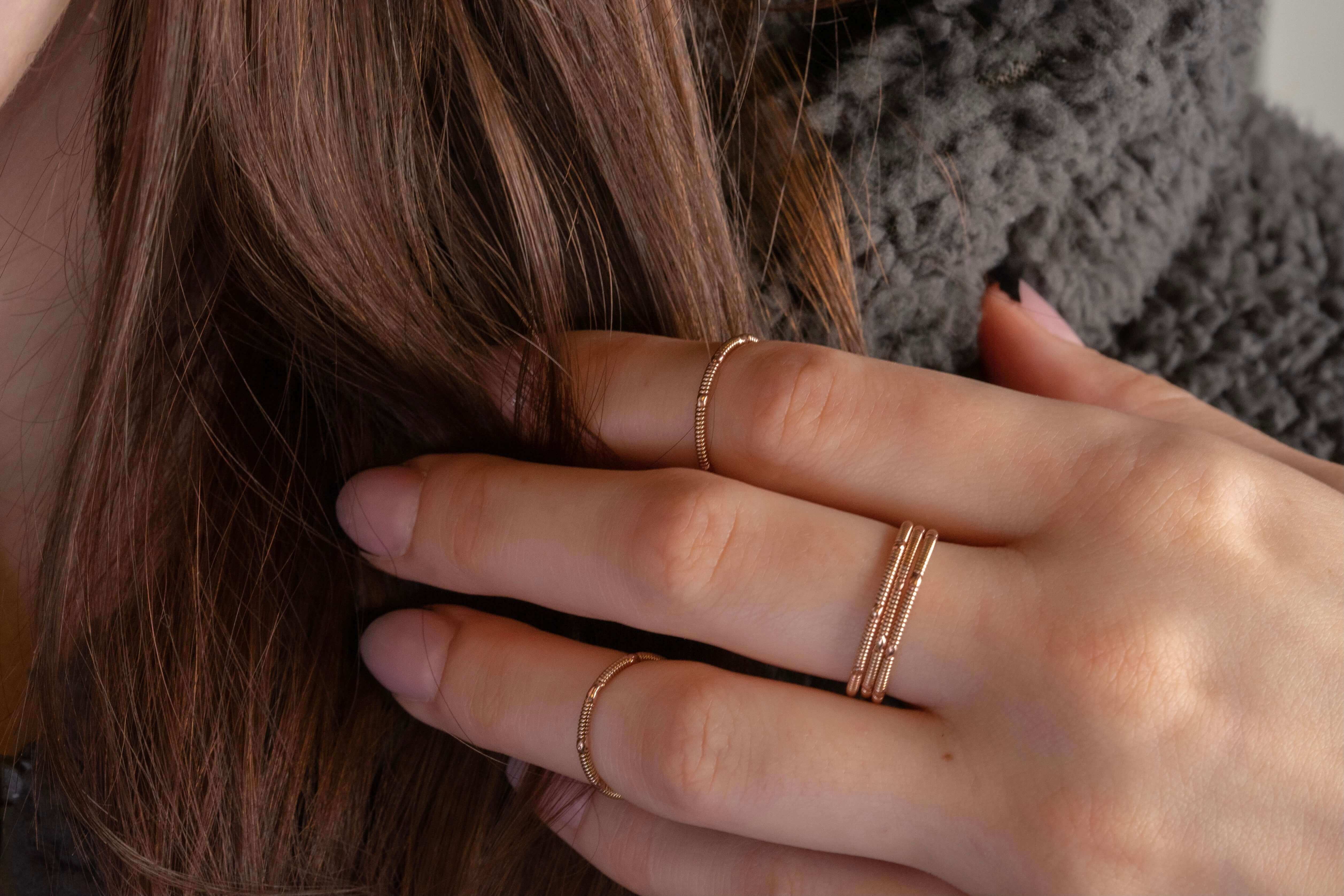 stacking duo guitar string rings on hand model touching hair