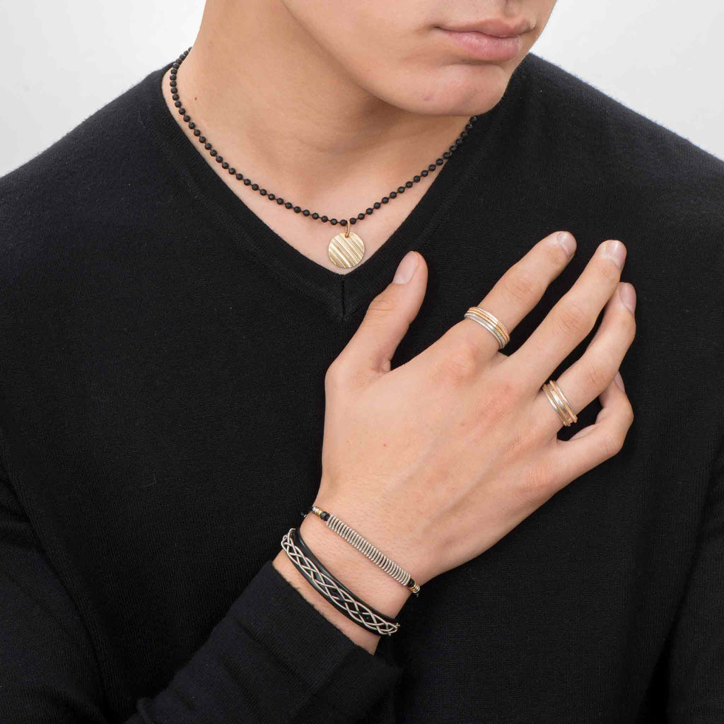 Urban electric guitar string jewelry collection on male model in black shirt and white background
