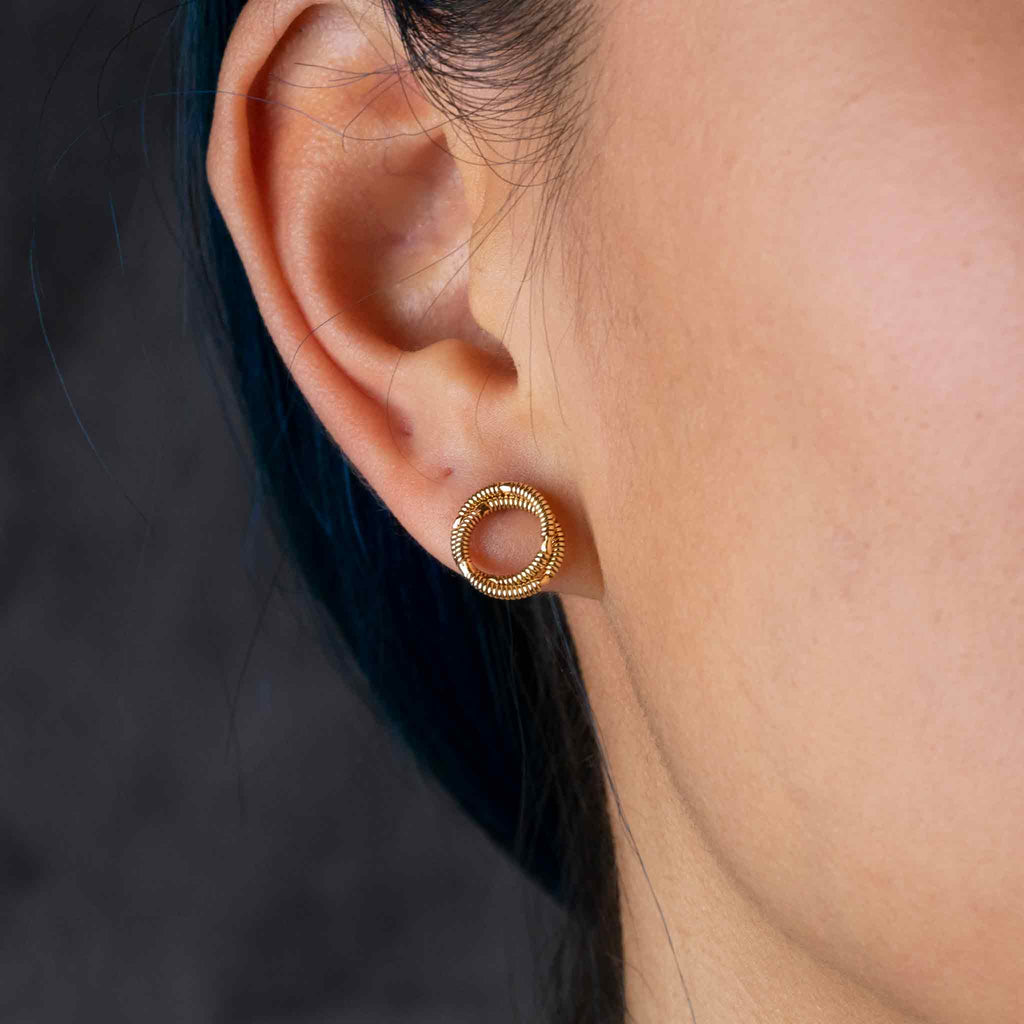 Duo guitar string stud earring, gold in colour,  on model