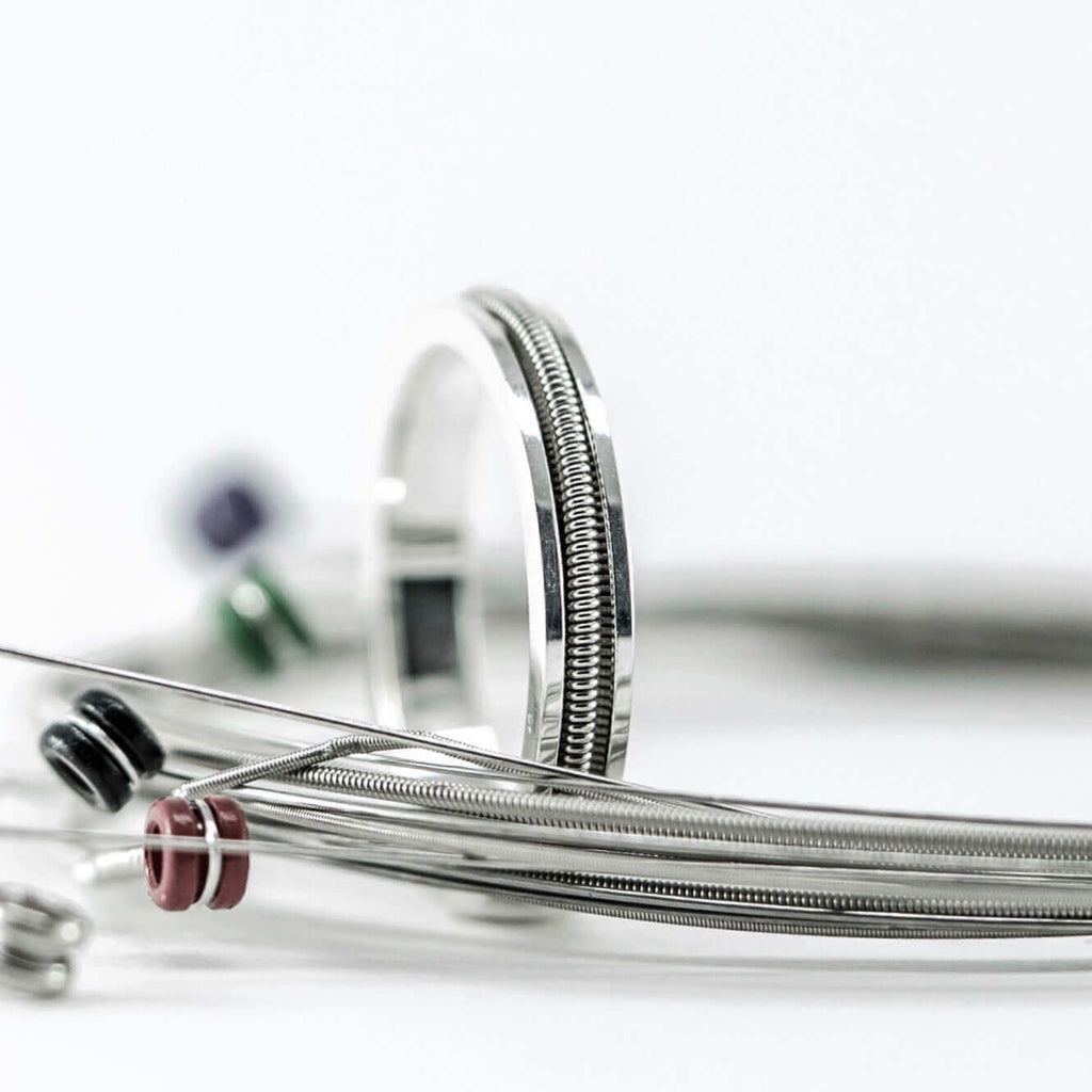 Electric guitar string surrounding a silver and electric guitar string ring
